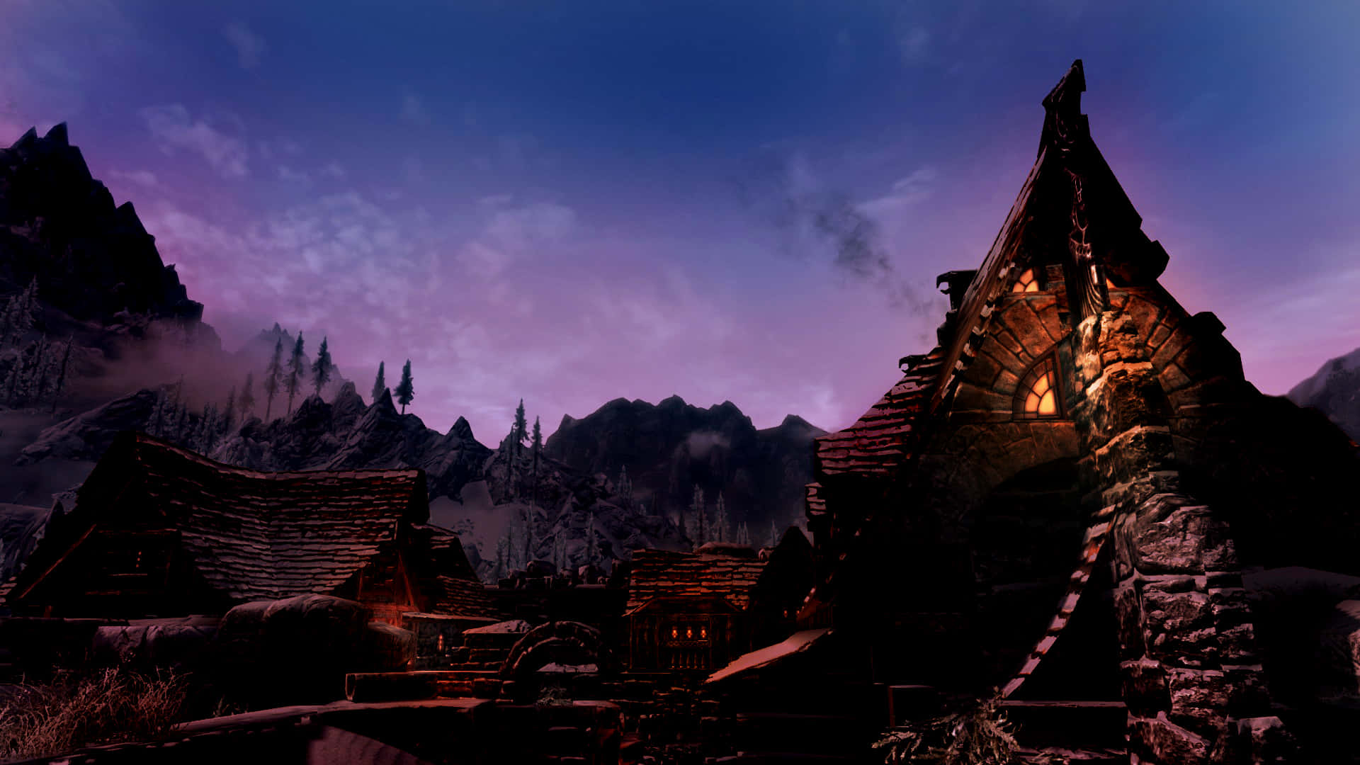 Skyrim Windhelm 桌布 壁紙 — 一間孤獨的石屋，窗戶透出光芒，坐落在暮色天空下霧氣繚繞的山巒之間。