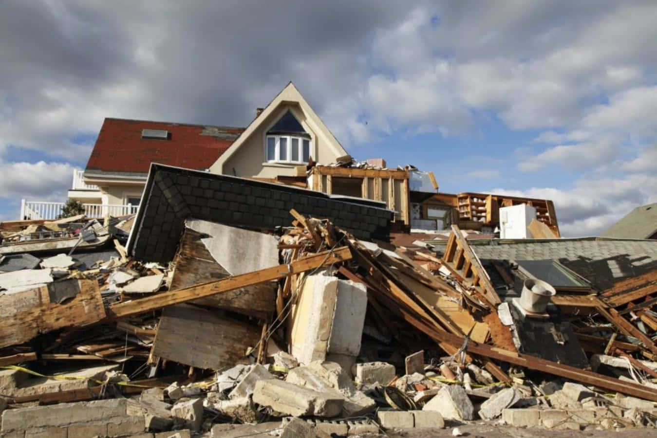 Natural Disaster 桌布 壁紙 — 一間房屋在陰天下部分倒塌，瓦礫堆中可見屋頂和牆壁受損。