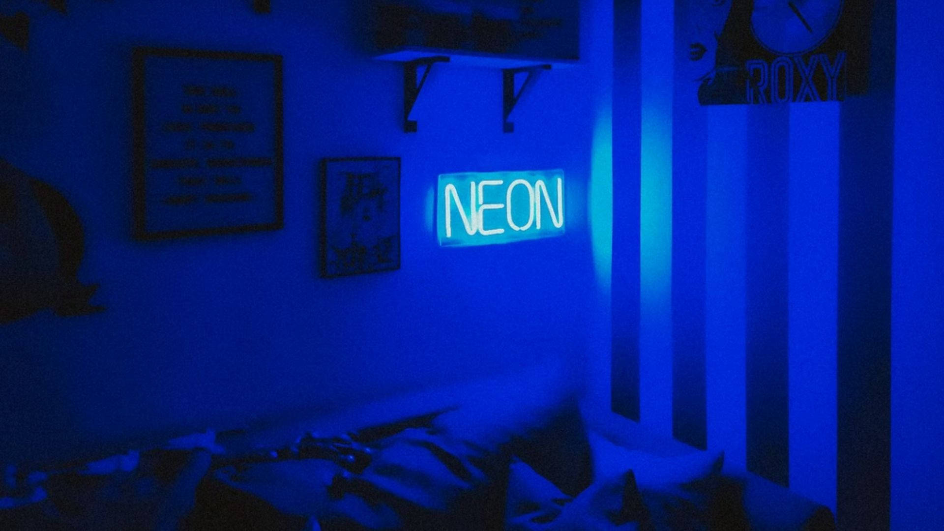 霓虹藍動畫 桌布 壁紙 — 一間昏暗的臥室沐浴在發光的「NEON」標誌發出的藍色霓虹光中，柔和光線投射在條紋牆壁和凌亂的床上。