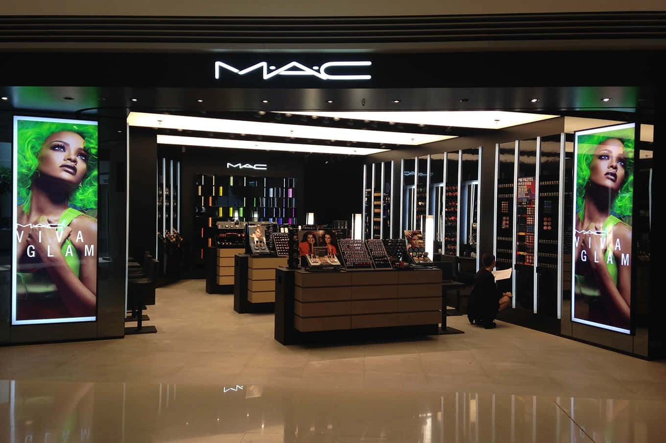 Mac Cosmetics 桌布 壁紙 — 一間時尚的MAC化妝品店，發光的綠色Viva Glam廣告兩側是拋光地板和展示櫃檯。