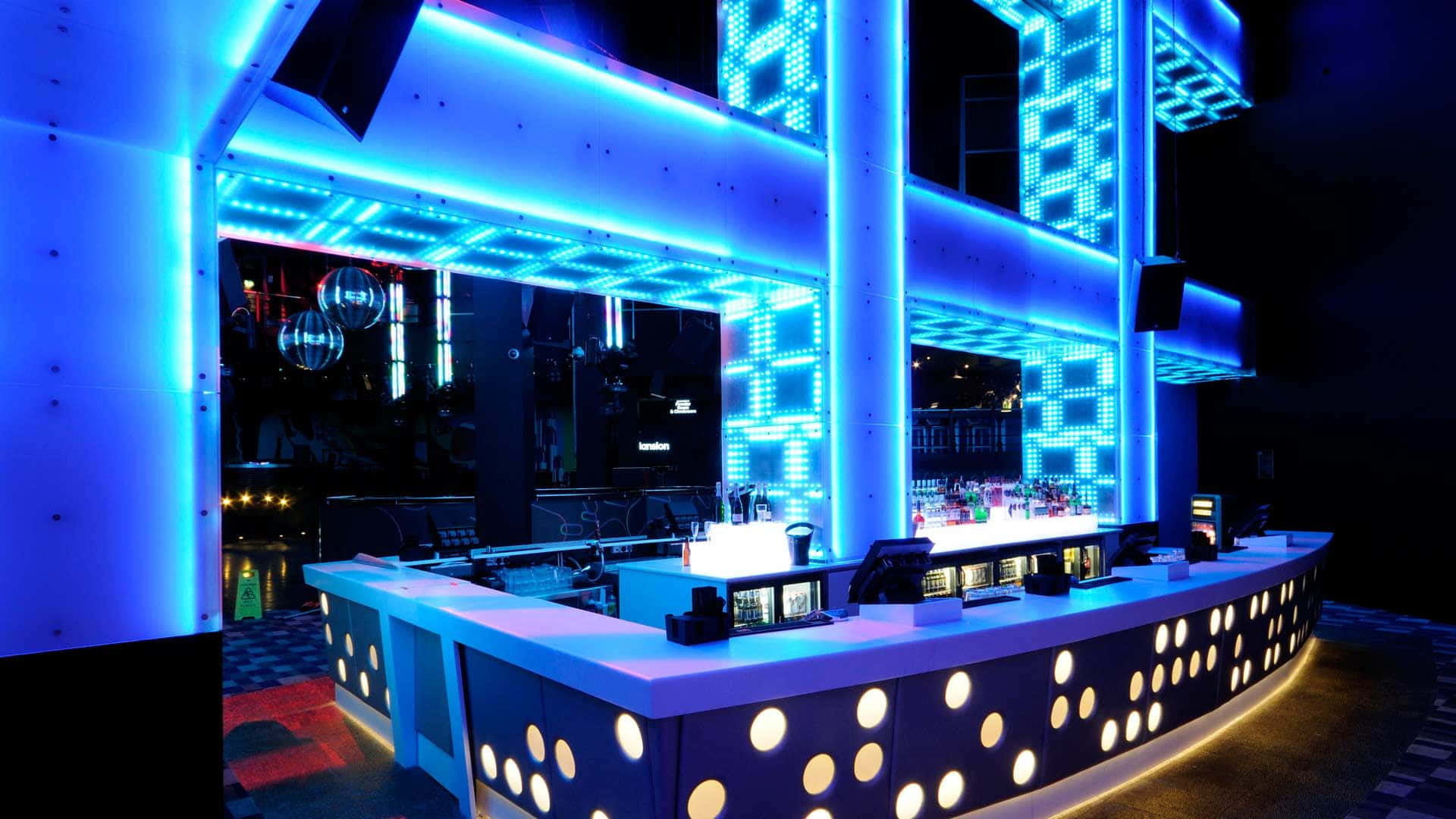 Nightclub 桌布 壁紙 — 一間未來風格的夜總會酒吧，在黑暗背景下散發著鮮豔的藍色霓虹燈光和圓形照明裝飾。
