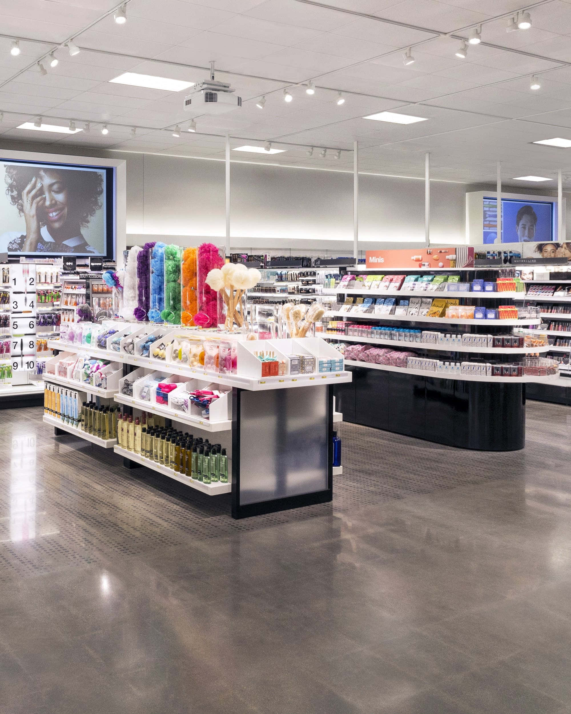 Shop 桌布 壁紙 — 一間燈光明亮的化妝品店，設有色彩繽紛的產品展示和顯示美容廣告的大型螢幕。