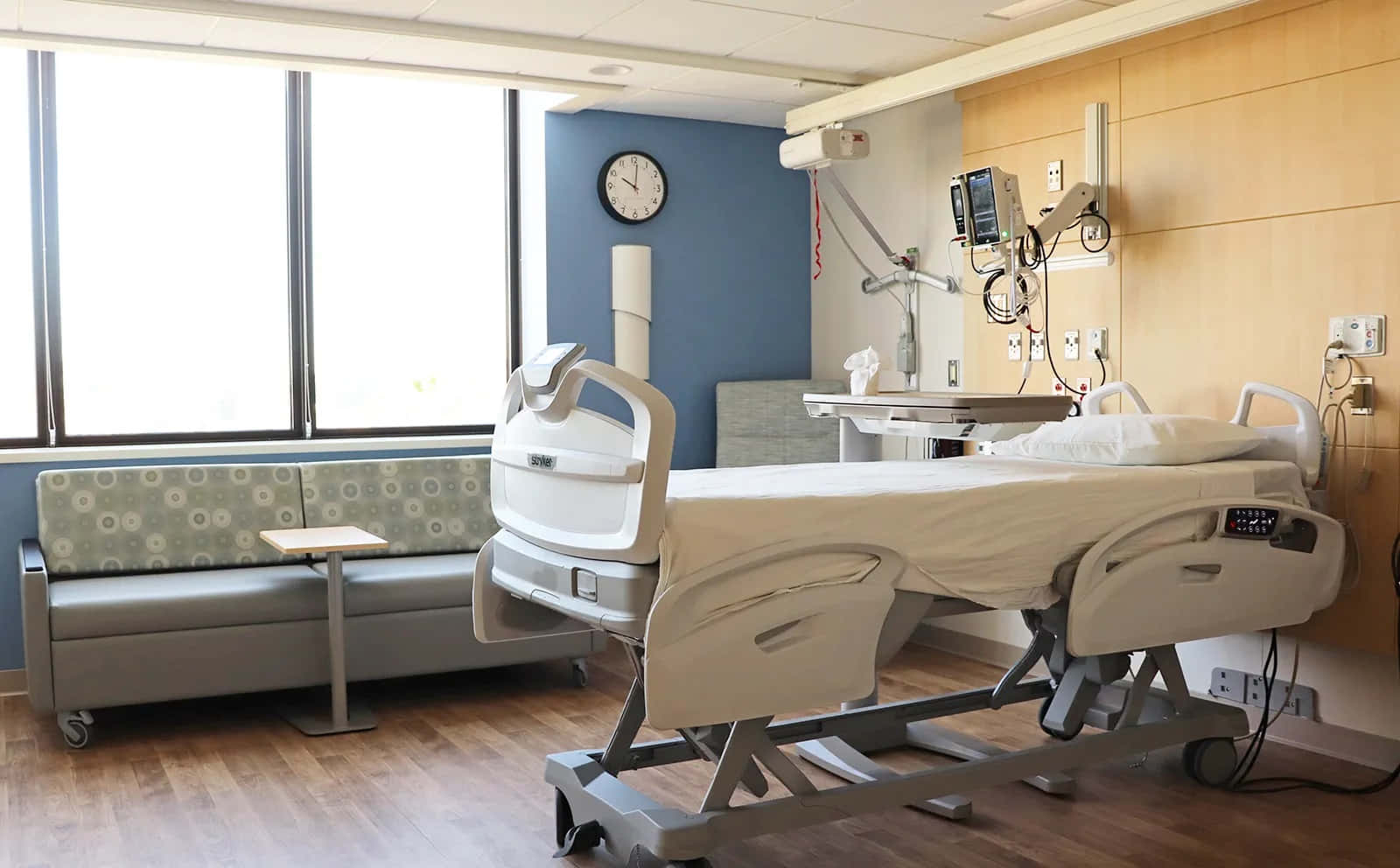 Hospital Room 桌布 壁紙 — 一間現代化病房，配備醫療床、病人監護儀，以及引入明亮日光的大窗。