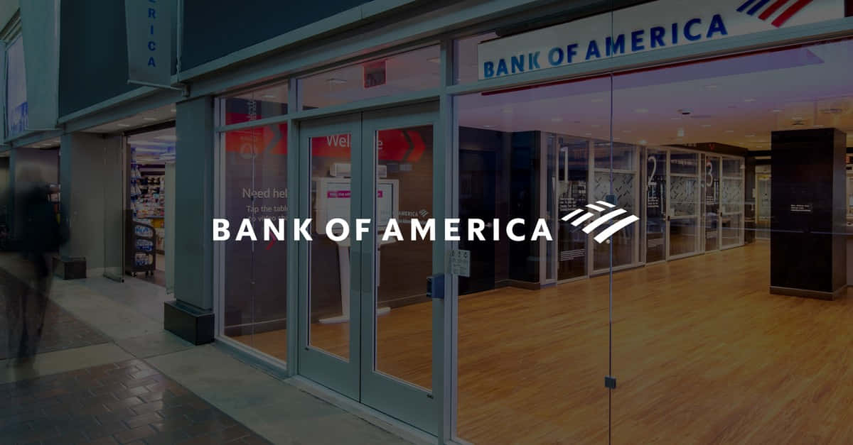 Bank Of America 桌布 壁紙 — 一間現代化的美國銀行分行，設有玻璃門和木地板，在傍晚燈光下。