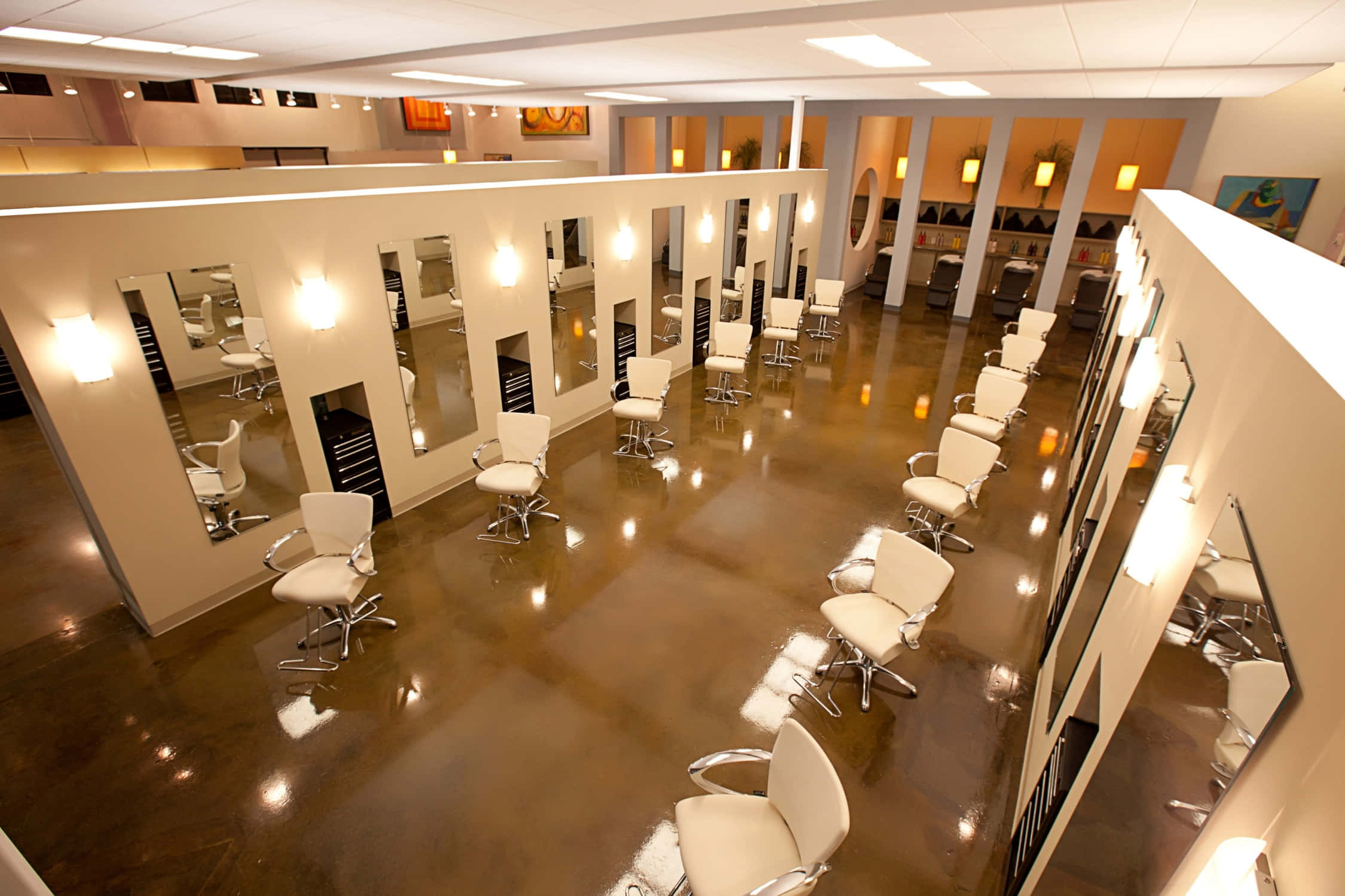 Hair Salon 桌布 壁紙 — 一間現代髮廊，在光亮的棕色地板上，溫暖的燈光下排列著白色的造型椅和鏡子。