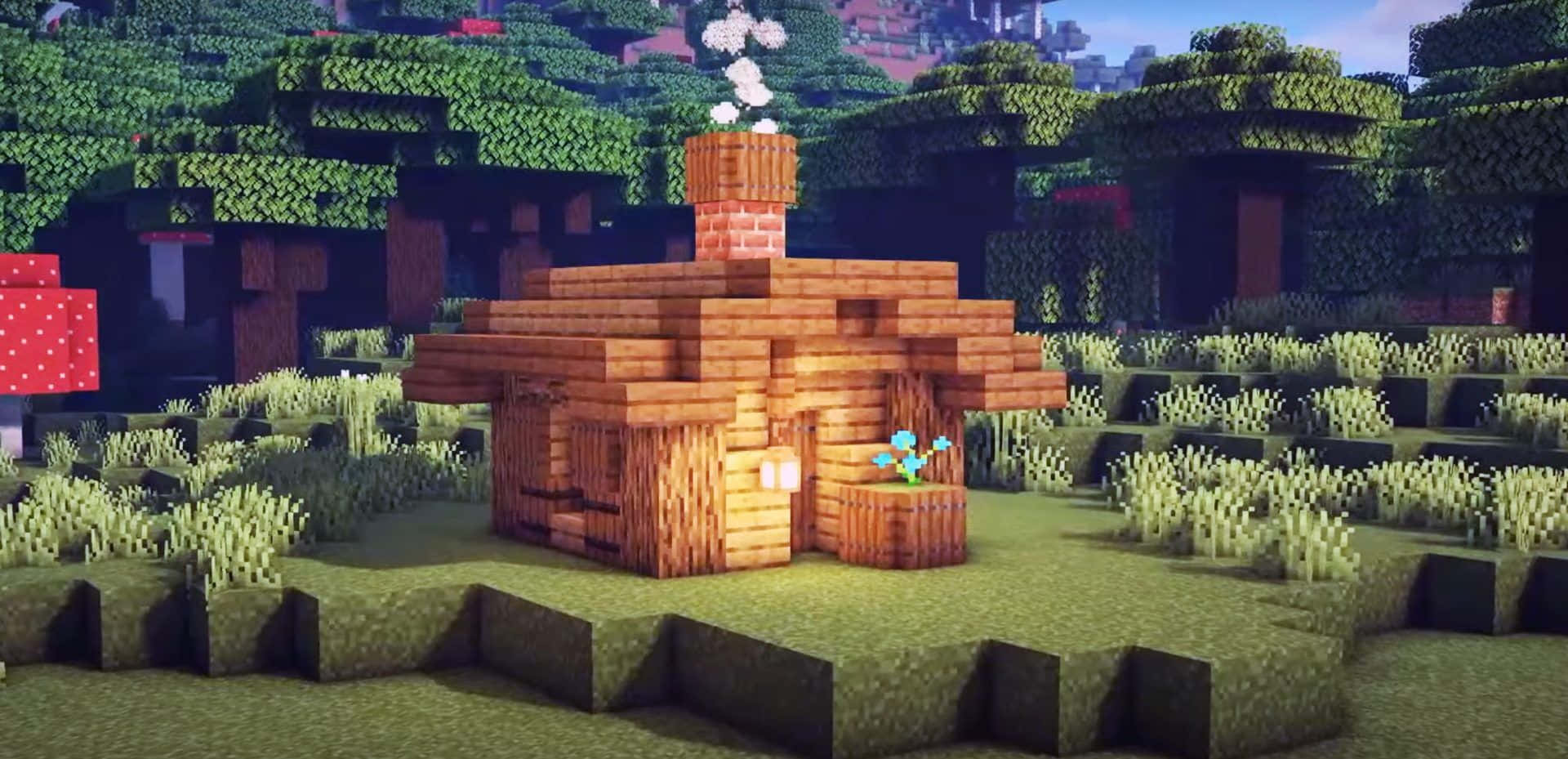 Minecraft Building 桌布 壁紙 — 一間舒適的像素風格木屋，煙囪冒著煙，坐落在一個有草地和樹木的方塊森林中，天空晴朗。