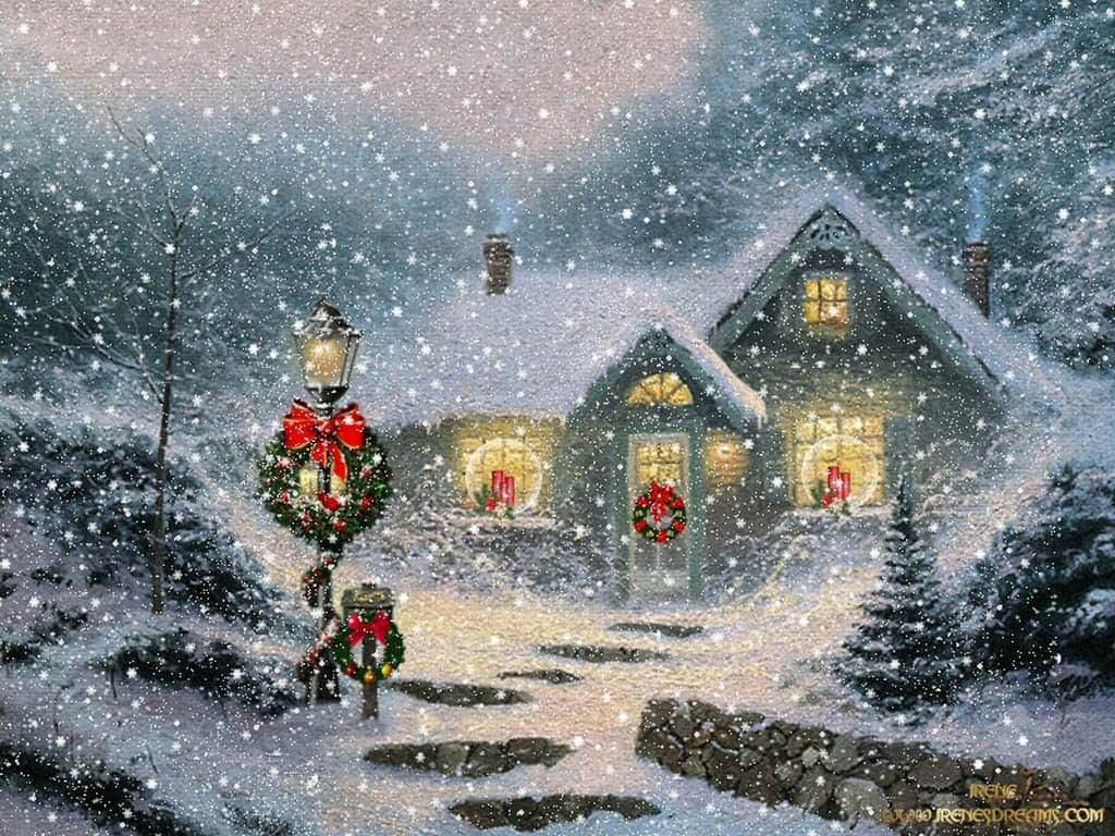 Cowboy Christmas 桌布 壁紙 — 一間舒適的雪覆蓋小屋，夜晚溫暖地亮著燈，裝飾著節日花環和飄落的雪花。