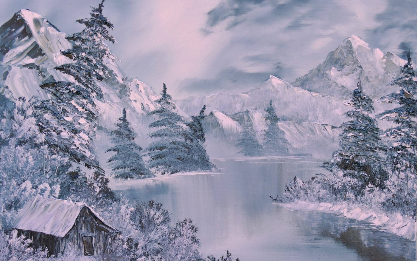 雪 桌布 壁紙 — 一間被雪覆蓋的小屋坐落在冰凍的湖邊，周圍環繞著高聳的常綠樹木和雄偉的雪山，天空多雲。