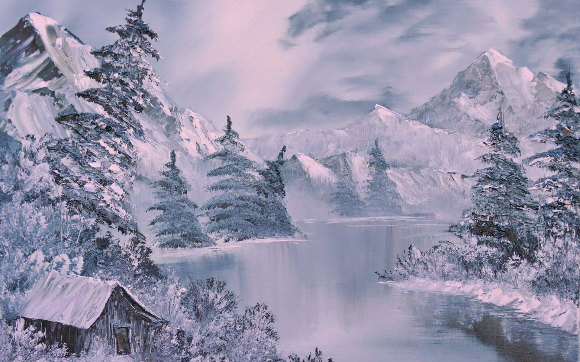 風景 桌布 壁紙 — 一間被雪覆蓋的小屋坐落在結冰的湖邊，周圍是高聳的常綠樹和遠山頂峰，天空多雲的冬日景象。