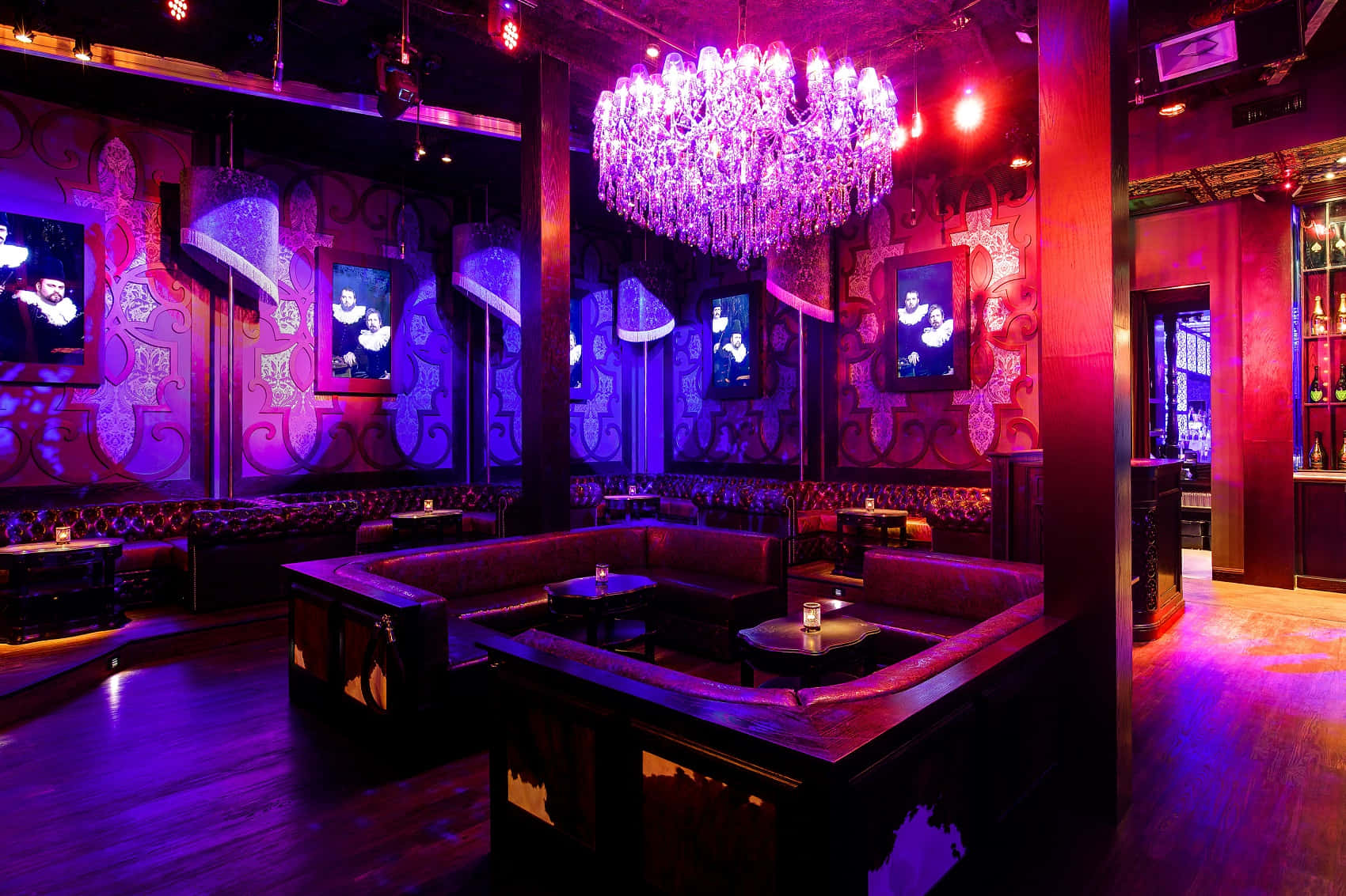 Nightclub 桌布 壁紙 — 一間豪華夜總會，紫色和紅色燈光下，閃爍的水晶吊燈下方設有豪華卡座。