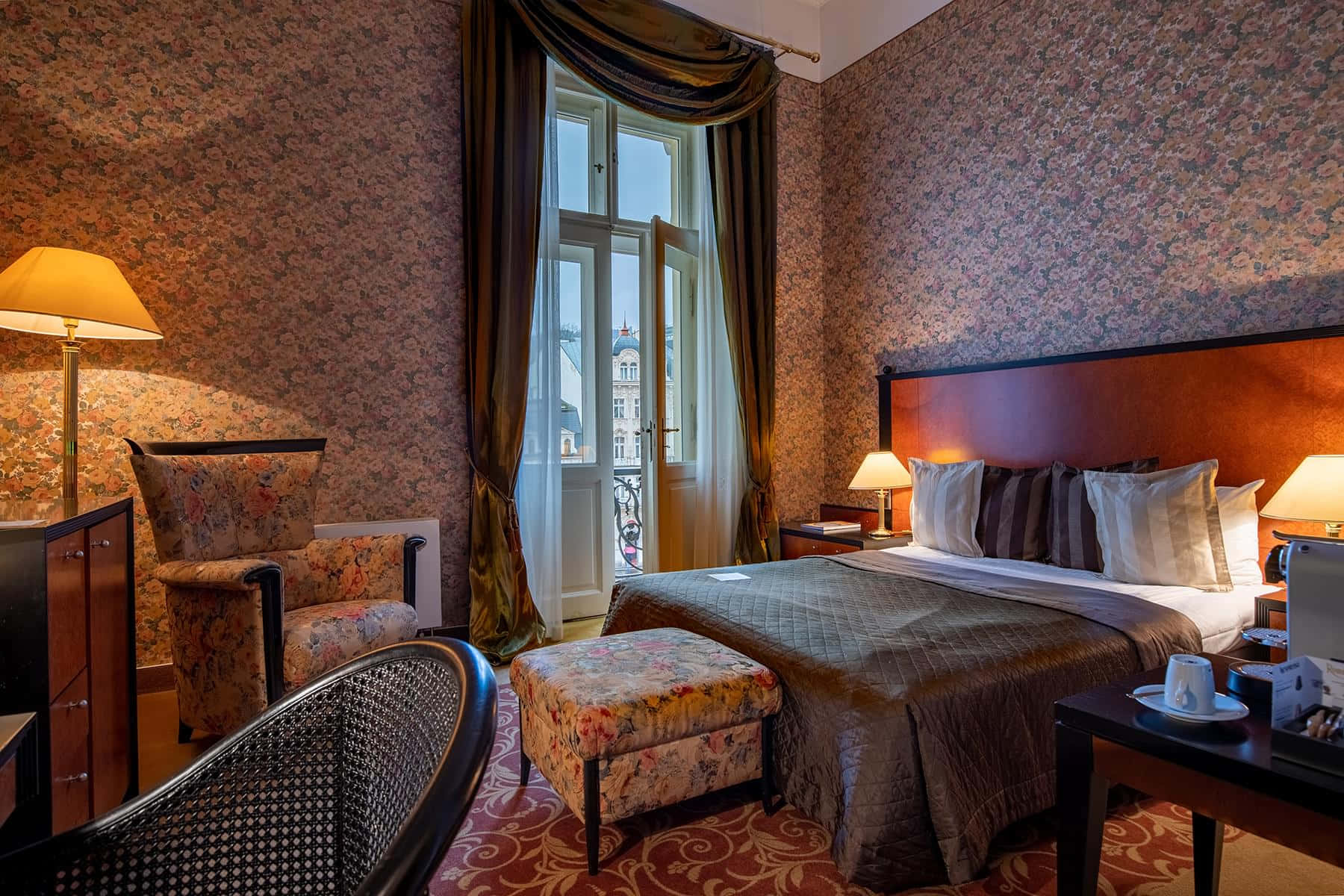 Bedroom 桌布 壁紙 — 一間豪華的復古飯店客房，配有花卉壁紙和一張大床，在溫暖的燈光下。