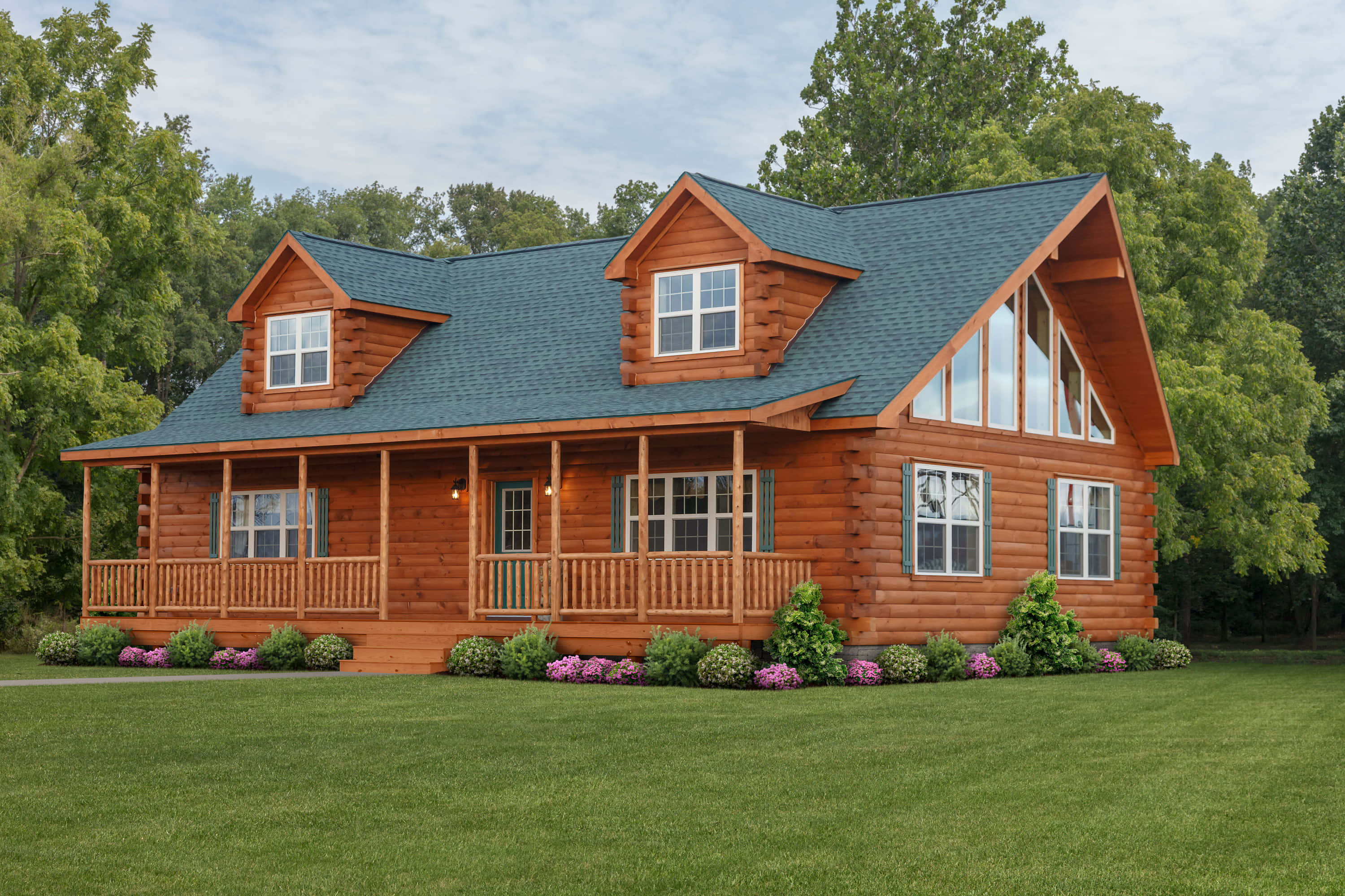 Log Cabin 桌布 壁紙 — 一間質樸的圓木小屋，帶有環繞式門廊和藍色屋頂，坐落在鬱鬱蔥蔥的綠色草坪上，四周環繞著高大的樹木。