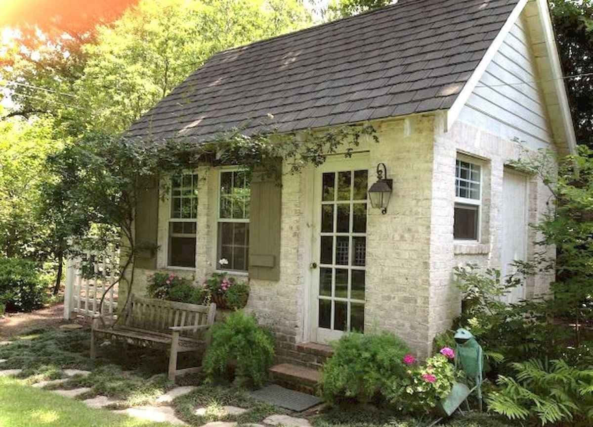Cottage 桌布 壁紙 — 一間迷人的白色小屋，配有綠色百葉窗和常春藤覆蓋的牆壁，坐落在一個沐浴在溫暖陽光下的茂密花園中。