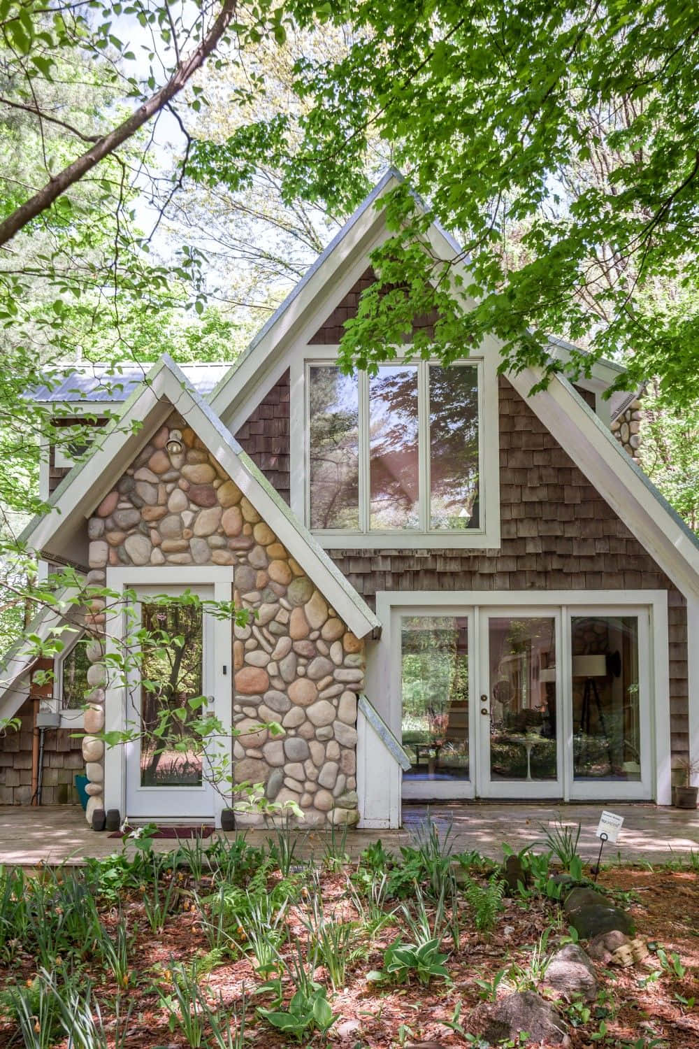 Cottage 桌布 壁紙 — 一間迷人的石頭和木瓦A字形小屋，坐落在茂密的綠樹下，前面有一個花園。