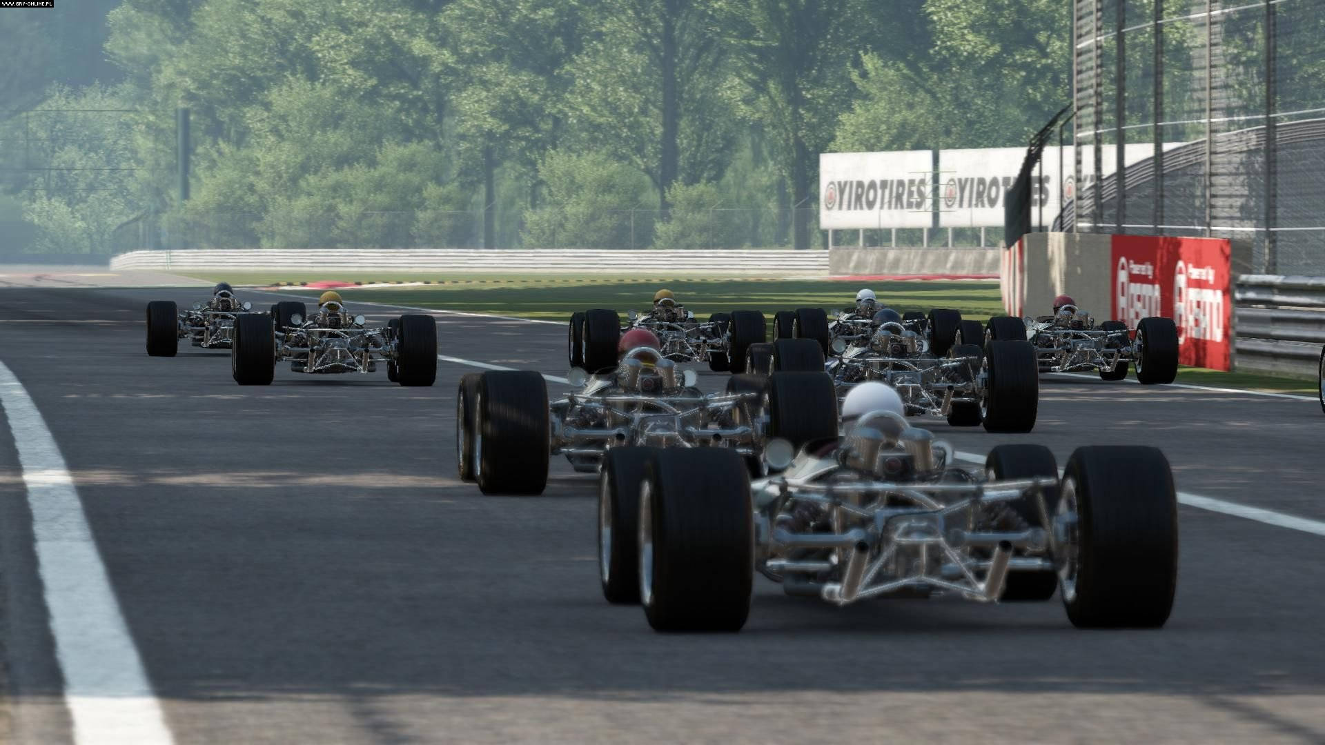 賽車卡丁車在日落時分的賽道上疾馳，背景有樹木和護欄。 — Project Cars 壁紙