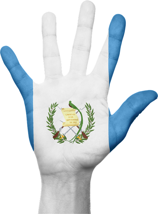 Flag 桌布 壁紙 — 一隻人手繪有瓜地馬拉國旗，藍色條紋，白色中心及國徽。