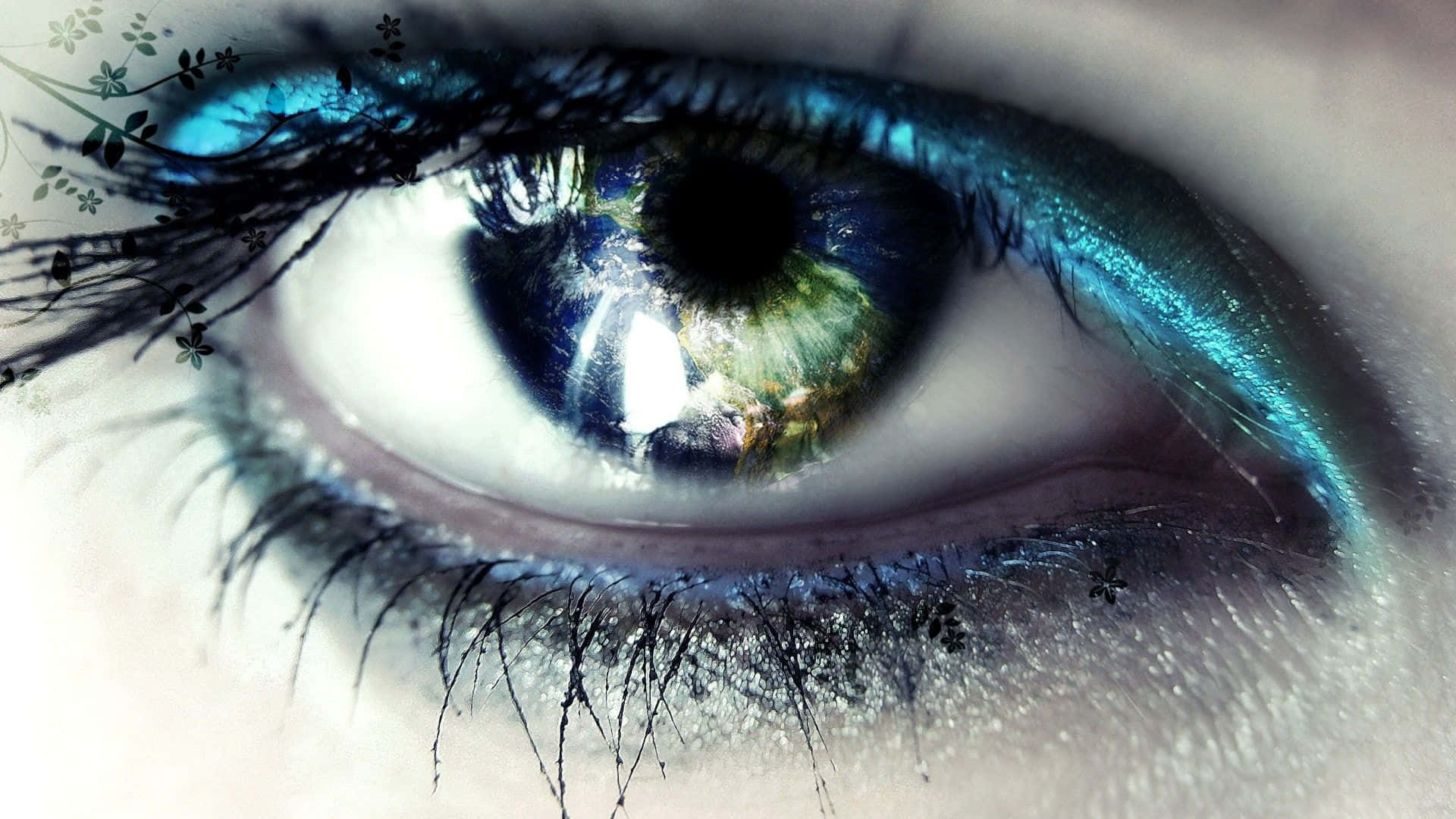 Eye 桌布 壁紙 — 一隻人眼的超現實特寫，虹膜呈現鮮豔的藍色和綠色，飾有閃閃發光的藍綠色化妝和精緻的黑色花卉圖案。