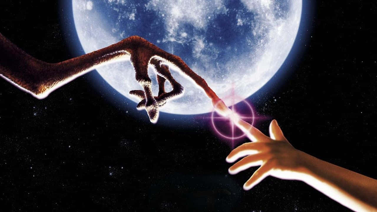 Et 桌布 壁紙 — 一隻人類的手伸向漂浮在太空中的恐龍手，前方是一顆巨大的藍色月亮。