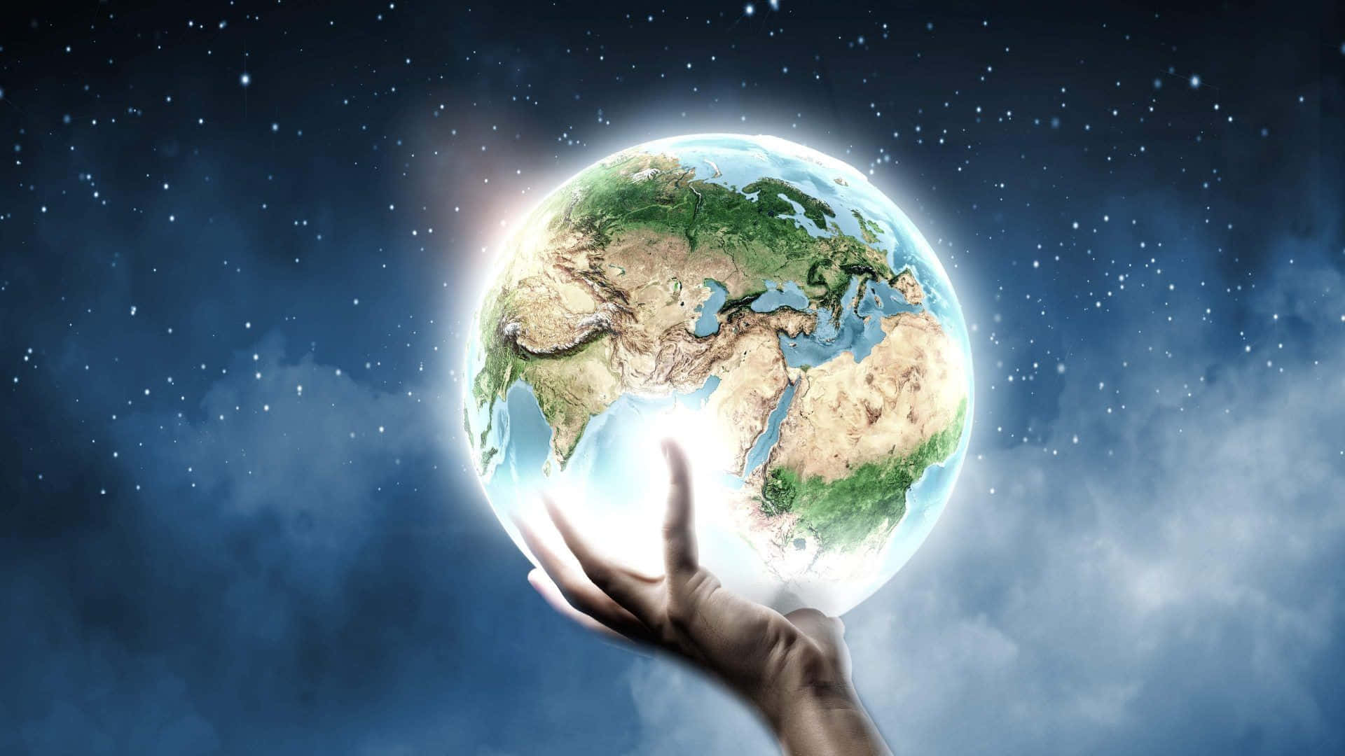 地球 桌布 壁紙 — 一隻人類的手輕輕托住一個發光的地球，背景是星光燦爛的宇宙和旋轉的雲層。