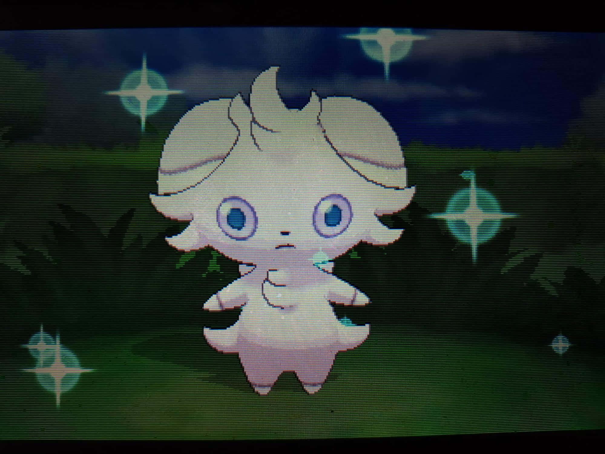 espurr 桌布 壁紙 — 一隻像素化的白色寶可夢，有著大大的藍色眼睛，站在黑暗的森林中，下方閃爍著星星般的光芒。