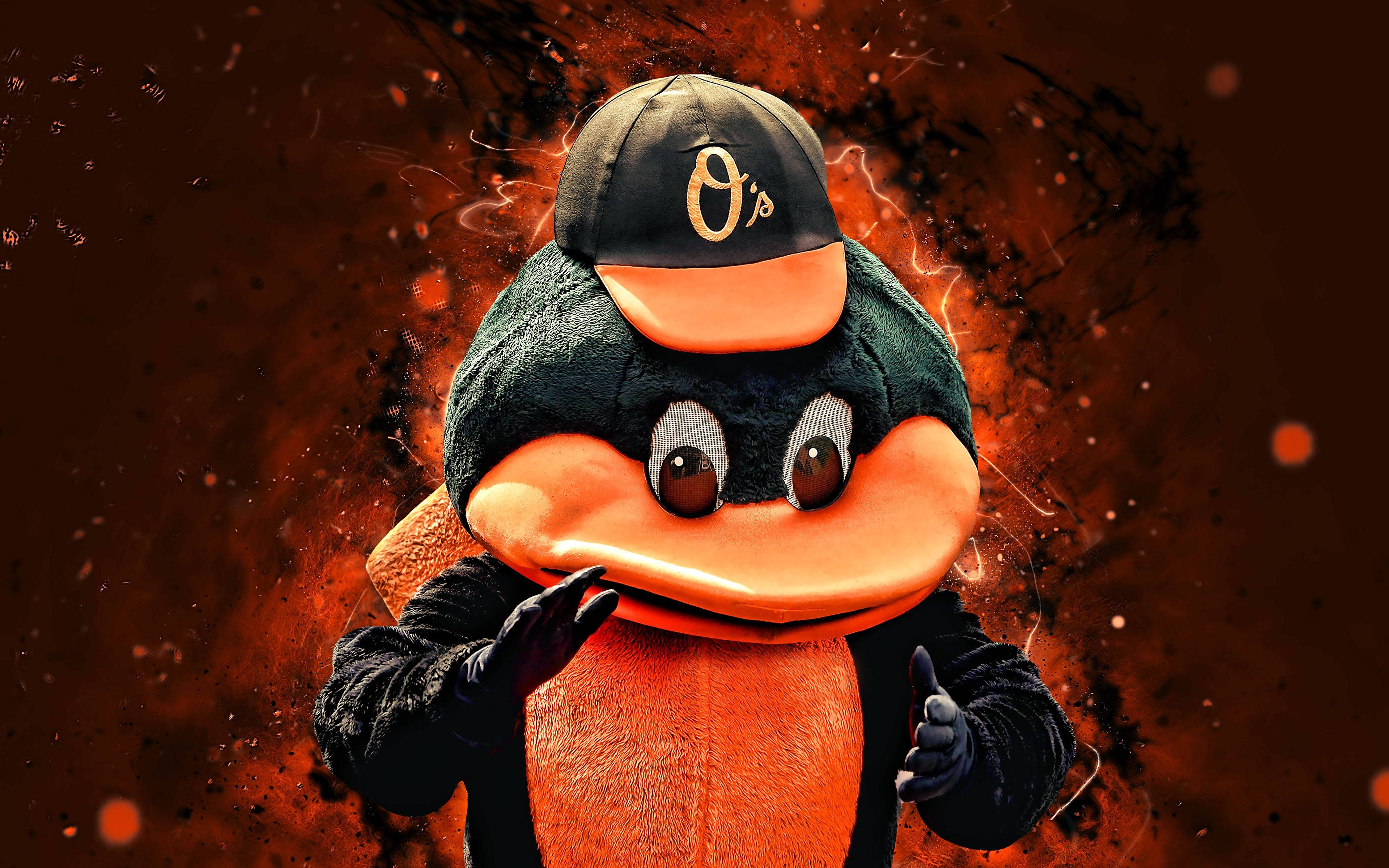 Orioles 桌布 壁紙 — 一隻充滿活力的橙色和黑色鴨子吉祥物，戴著帶有 O 標誌的帽子，在熾熱的橙色和黑色爆炸背景前豎起兩個大拇指。