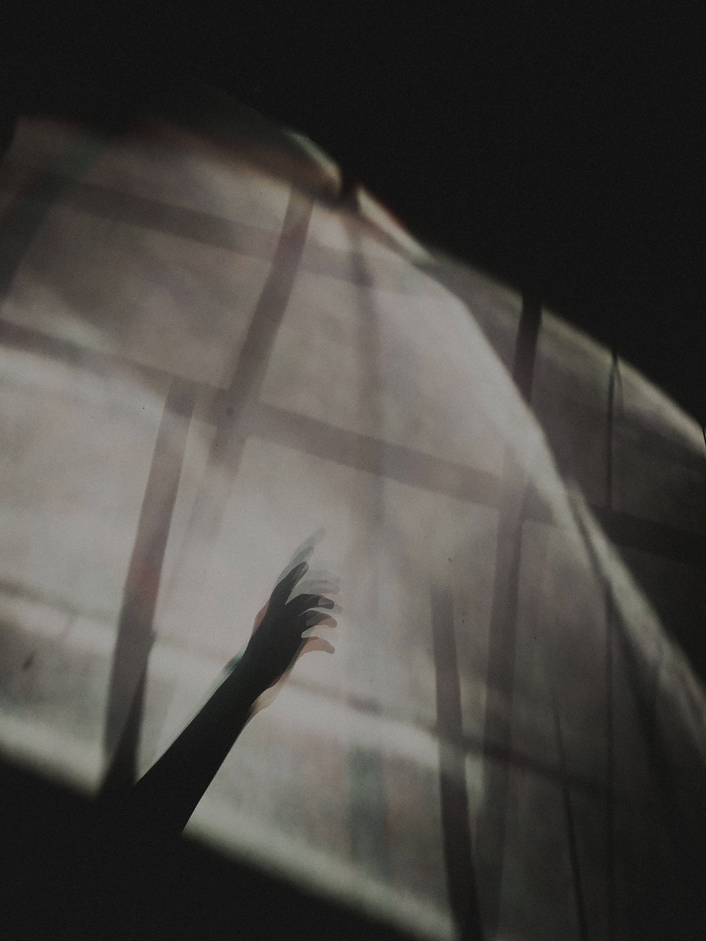 Depression Aesthetic 桌布 壁紙 — 一隻剪影手伸向透過薄紗窗簾的柔和光線，帶有幾何陰影。