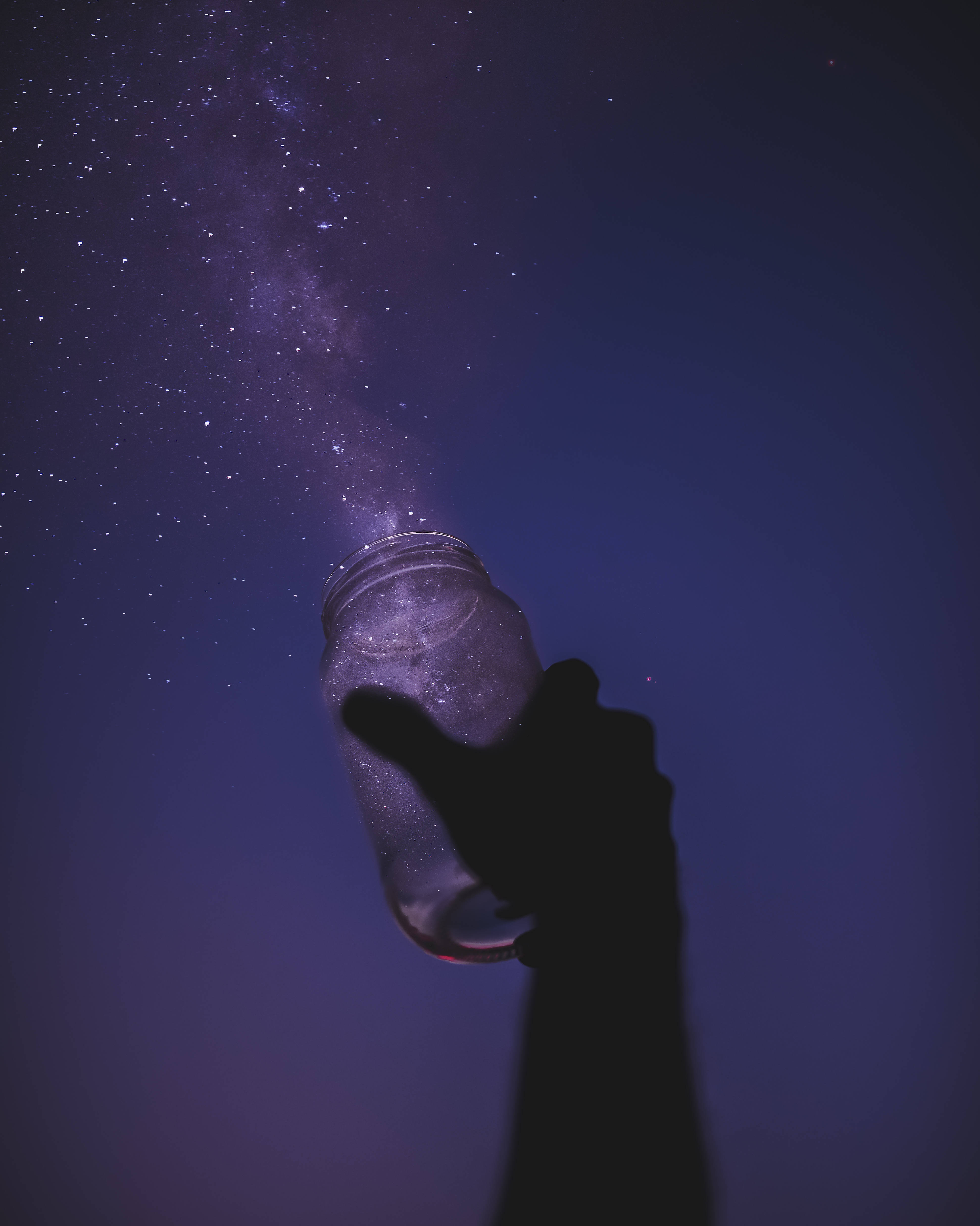 dreamy 桌布 壁紙 — 一隻剪影的手拿著一個罐子，閃爍的星星從中傾瀉到天鵝絨般的夜空。