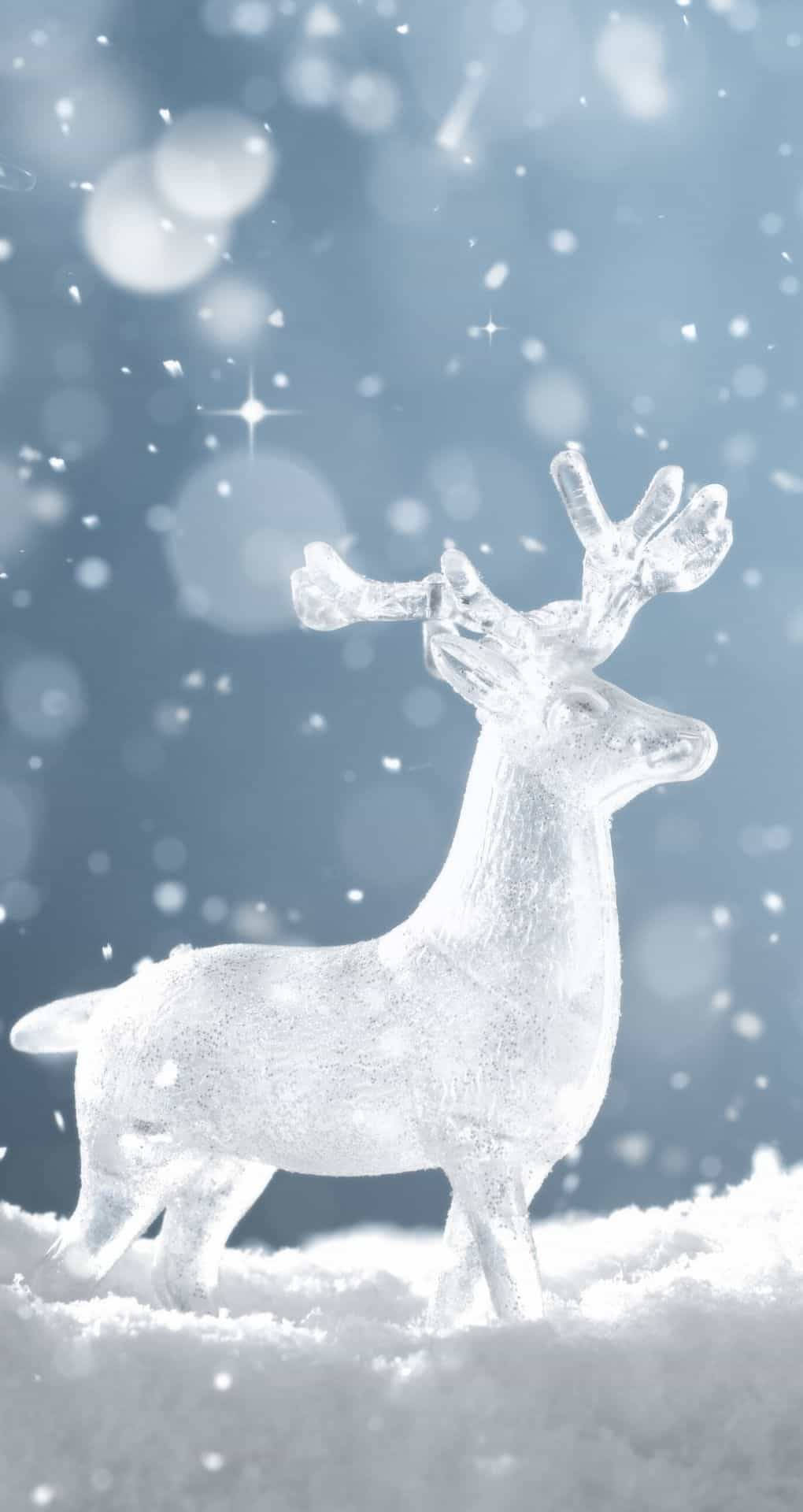 冬季 iPhone 壁紙 桌布 壁紙 — 一隻半透明的冰馴鹿優雅地站立在飄雪中，背景是柔和的藍色散景和閃爍的星星。