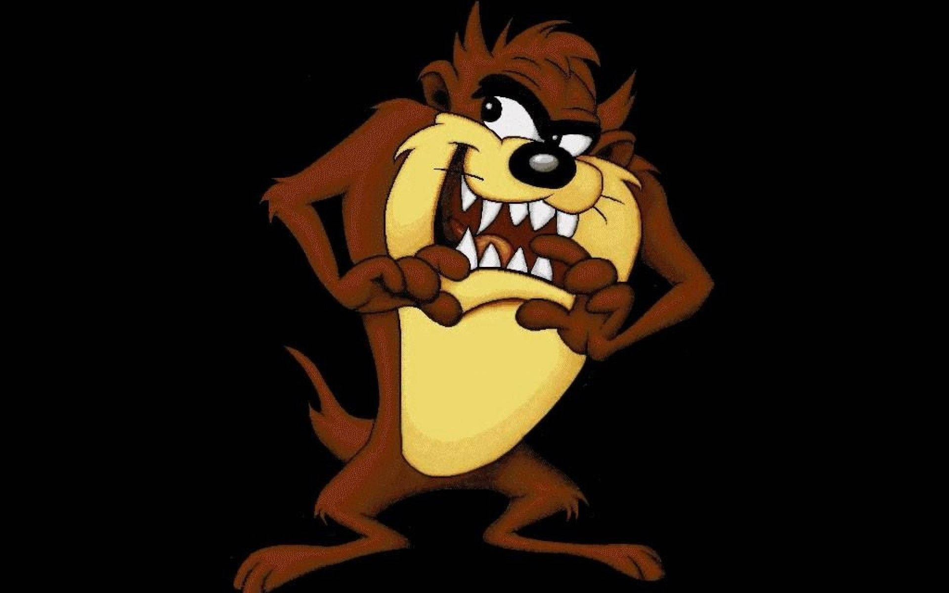 tasmanian devil 桌布 壁紙 — 一隻卡通塔斯馬尼亞惡魔，有棕色毛皮和黃色腹部，在黑色背景上憤怒地站立，露出鋒利的牙齒和爪子。
