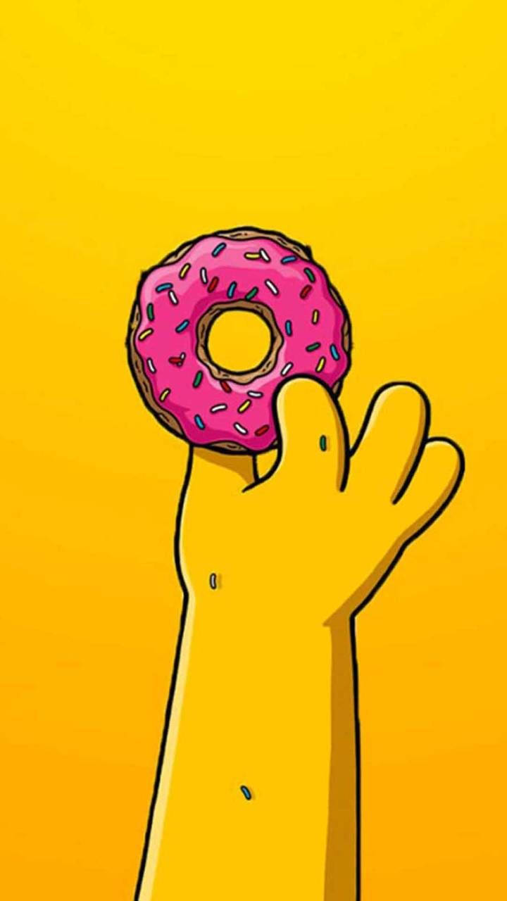 homer 桌布 壁紙 — 一隻卡通手拿著一個有彩色糖粒的粉紅色糖霜甜甜圈，背景是純黃色。