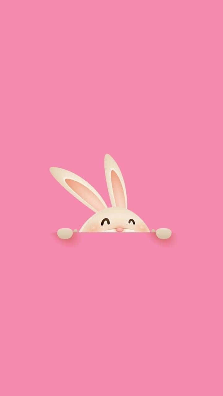 Pink Bunny 桌布 壁紙 — 一隻可愛的卡通兔子在粉紅色表面上探出頭來，帶著開心的笑容和小小的爪子。