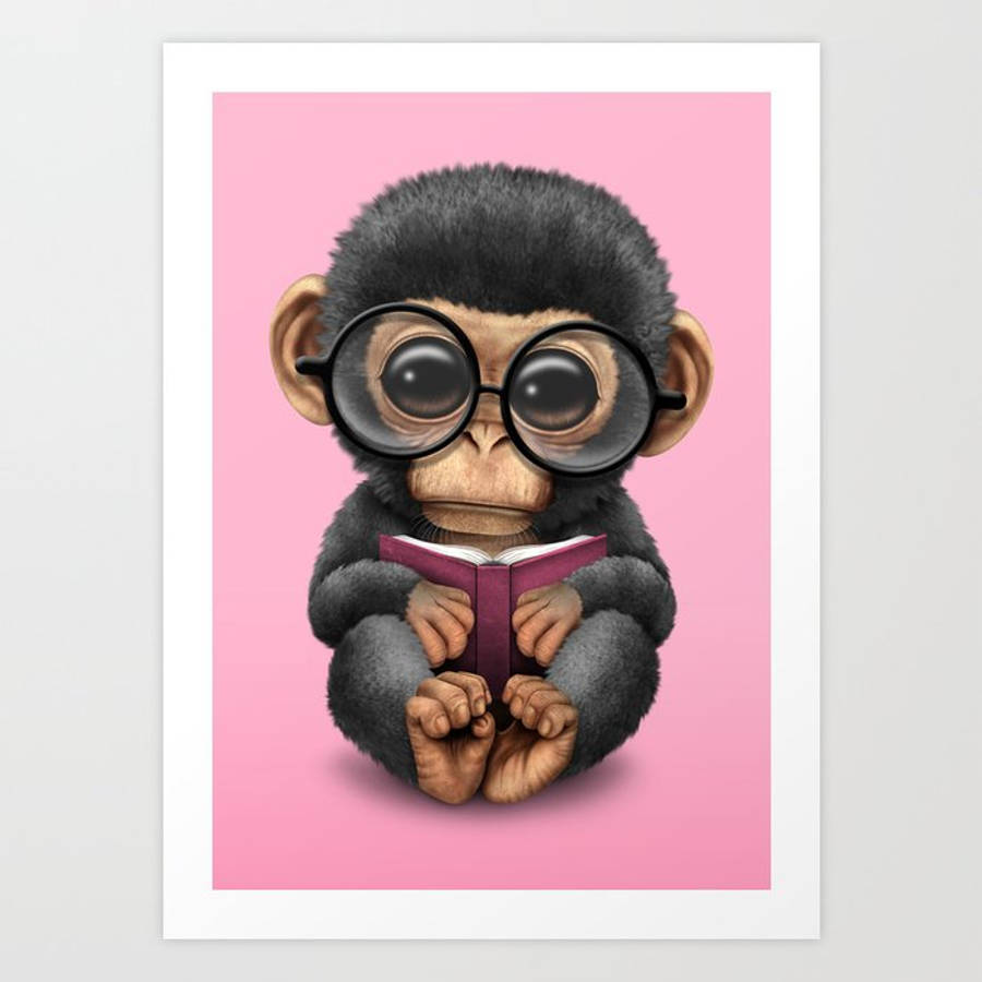 Baby Monkey 桌布 壁紙 — 一隻可愛的小猩猩戴著超大圓框眼鏡，在柔和粉紅色背景前閱讀一本紫色書。