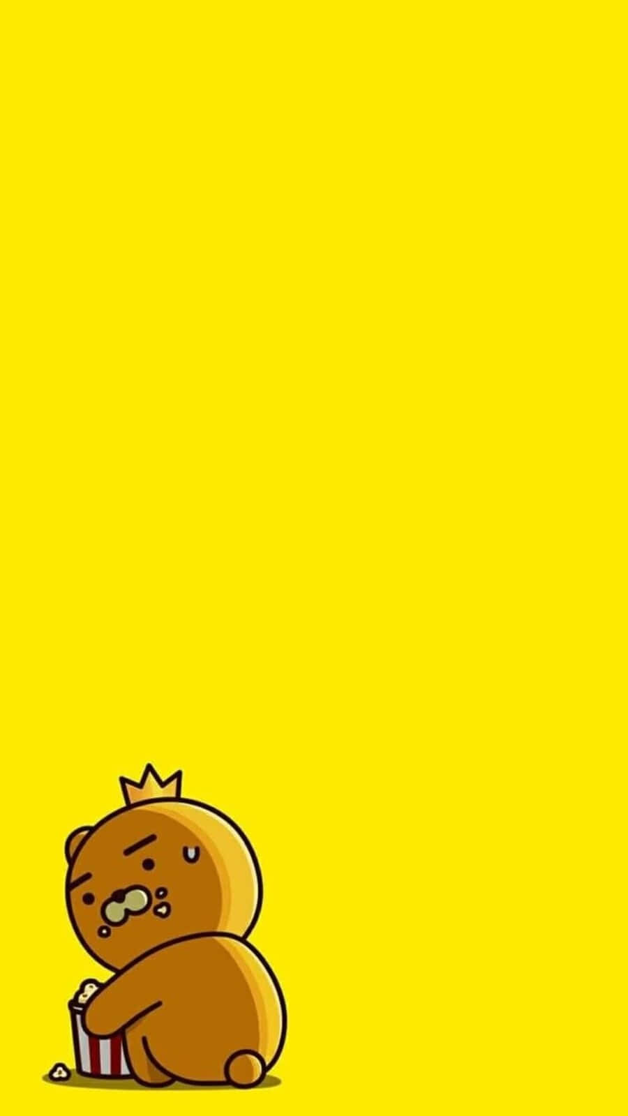 Kawaii Bear 桌布 壁紙 — 一隻可愛的棕色小熊戴著小皇冠，坐在明亮的黃色背景底部，帶著睡眼惺忪的表情吃爆米花。