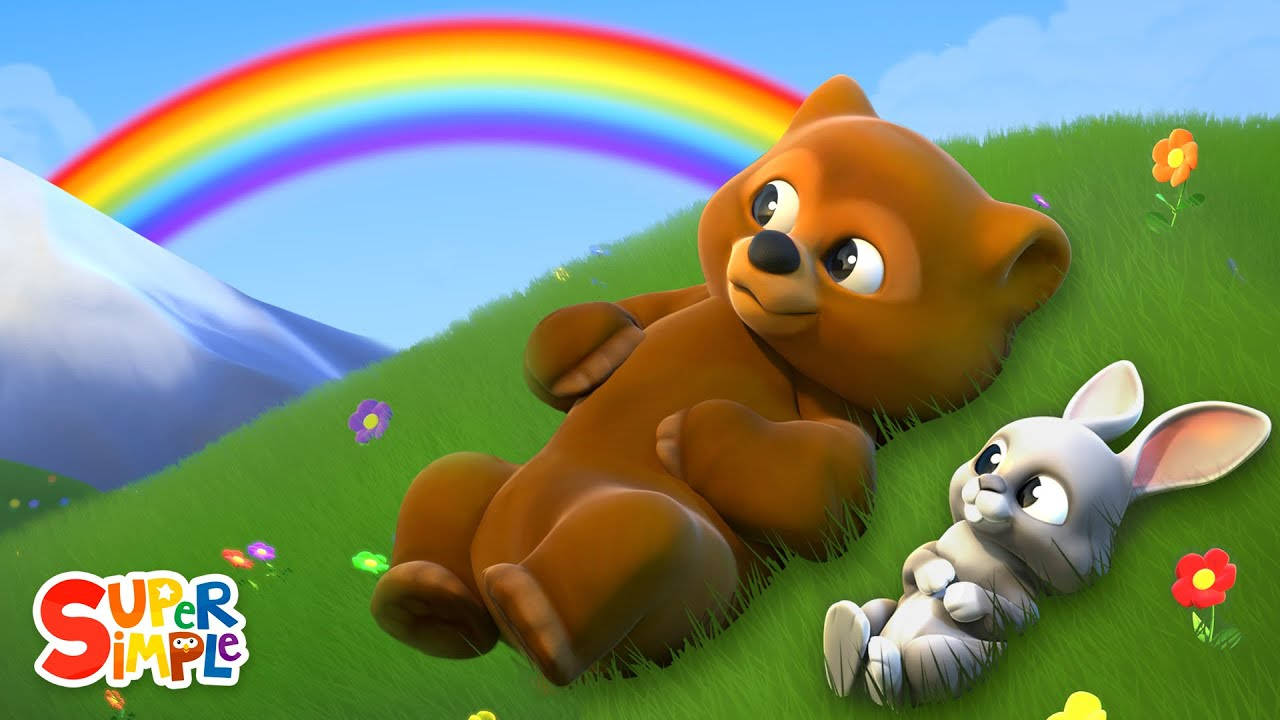 Rabbit 桌布 壁紙 — 一隻可愛的棕色熊和白色兔子在草地上休息，背景是山脈和鮮豔的彩虹。