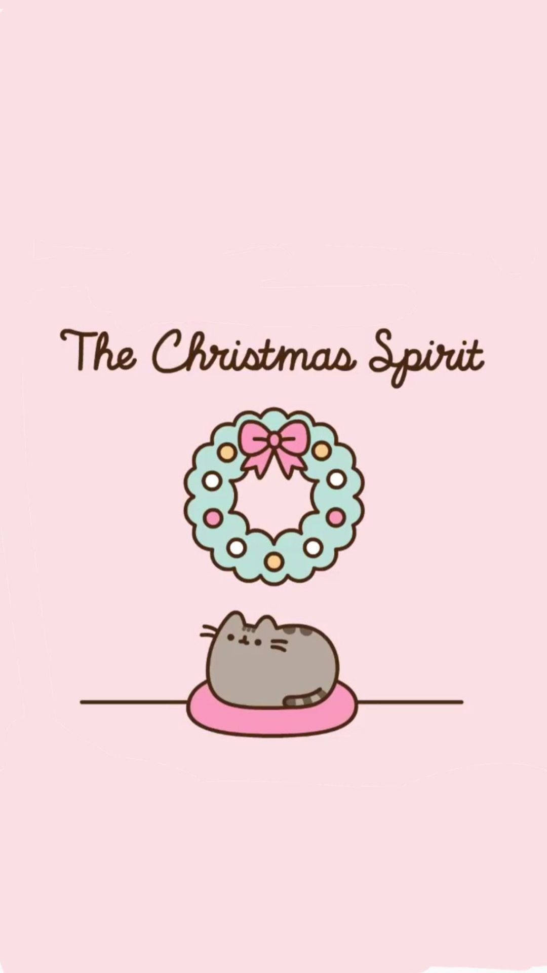 Kawaii Christmas 桌布 壁紙 — 一隻可愛的灰色貓咪坐在粉紅色墊子上，下方是帶有粉紅色蝴蝶結的節日花環，背景是柔和的粉紅色。