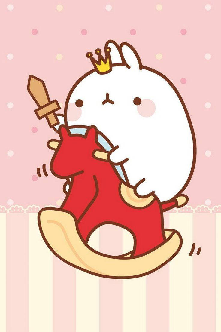 Molang 桌布 壁紙 — 一隻可愛的白兔戴著皇冠，騎著紅色搖木馬，手持木劍，背景是粉紅色圓點。