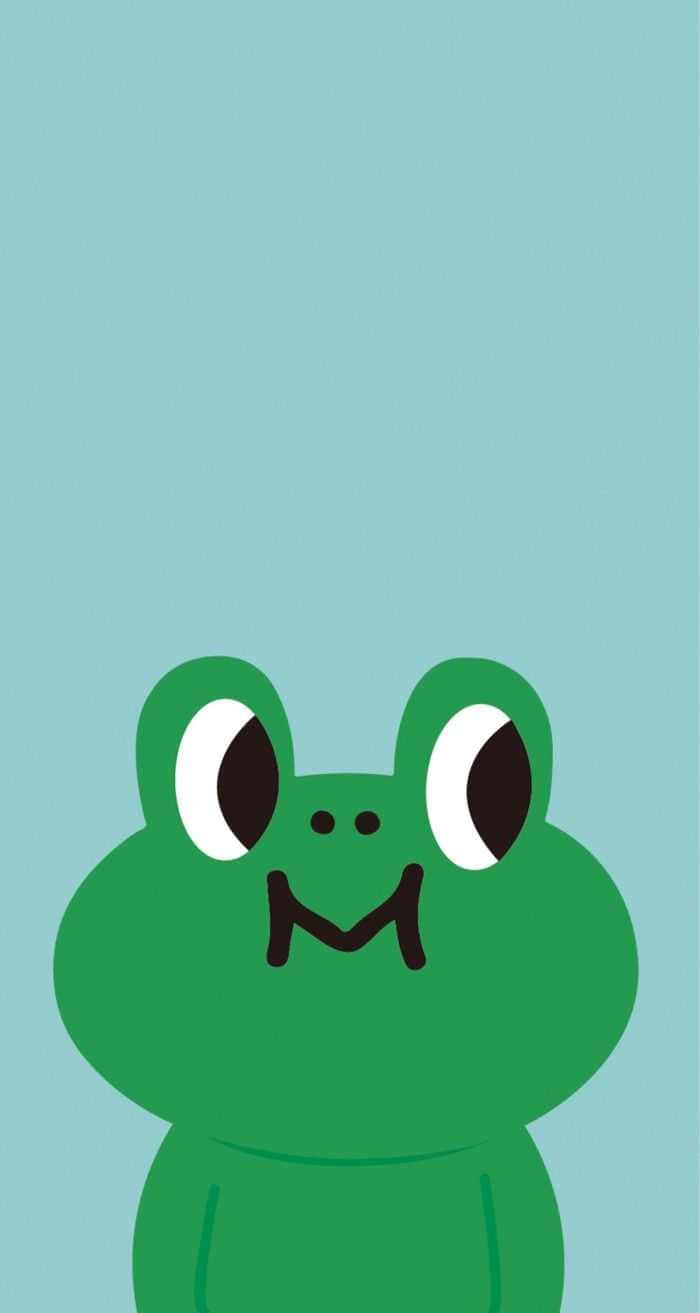 Frog 桌布 壁紙 — 一隻可愛的綠色卡通青蛙，有大眼睛和微笑的M形嘴巴，在淺藍色背景上。