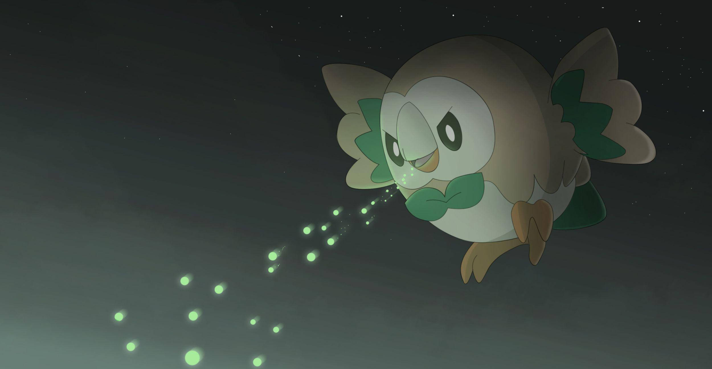 Rowlet 桌布 壁紙 — 一隻可愛的貓頭鷹狀寶可夢在滿天星斗的夜空滑翔，身後留下一串發光的綠色球體。