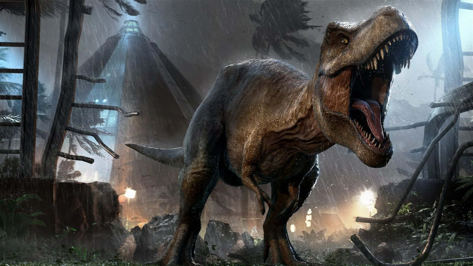 Jurassic World 桌布 壁紙 — 一隻咆哮的暴龍站在雨淋的叢林中，背景迷霧中有廢墟和發光的燈光。