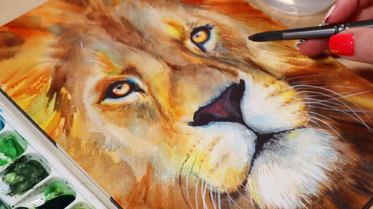 Lion Head 桌布 壁紙 — 一隻塗了紅色指甲油的手，用畫筆在綠色顏料調色盤旁邊繪畫一個細緻的水彩獅子臉。