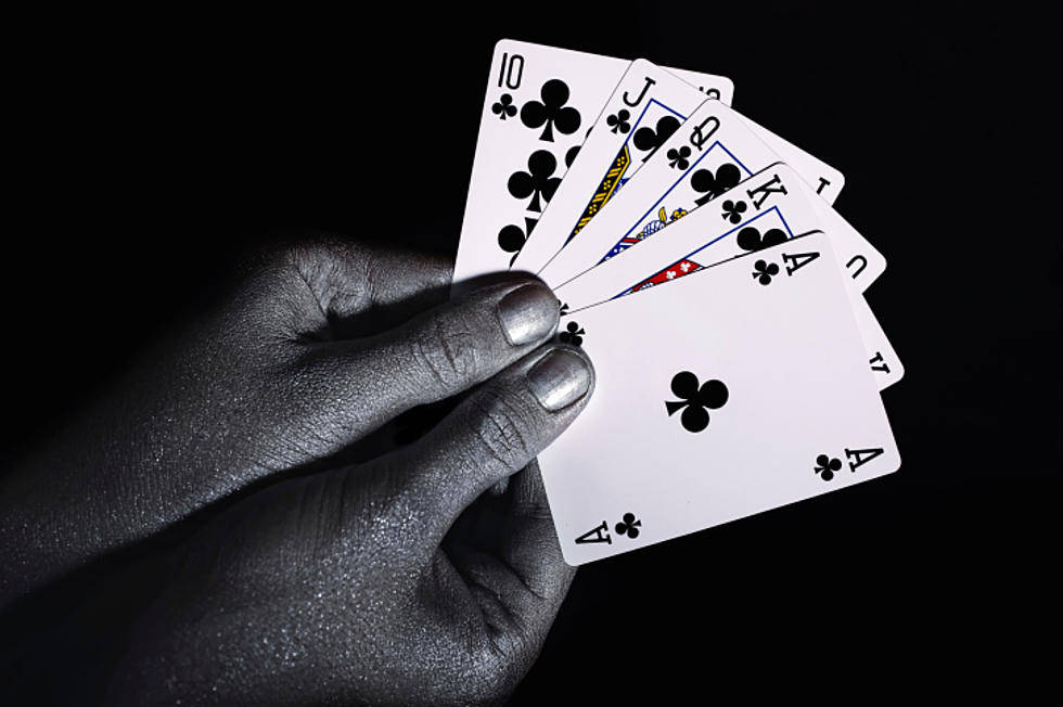Playing Cards 桌布 壁紙 — 一隻塗有銀色指甲油的手在黑色背景前拿著一把扇形的撲克牌。