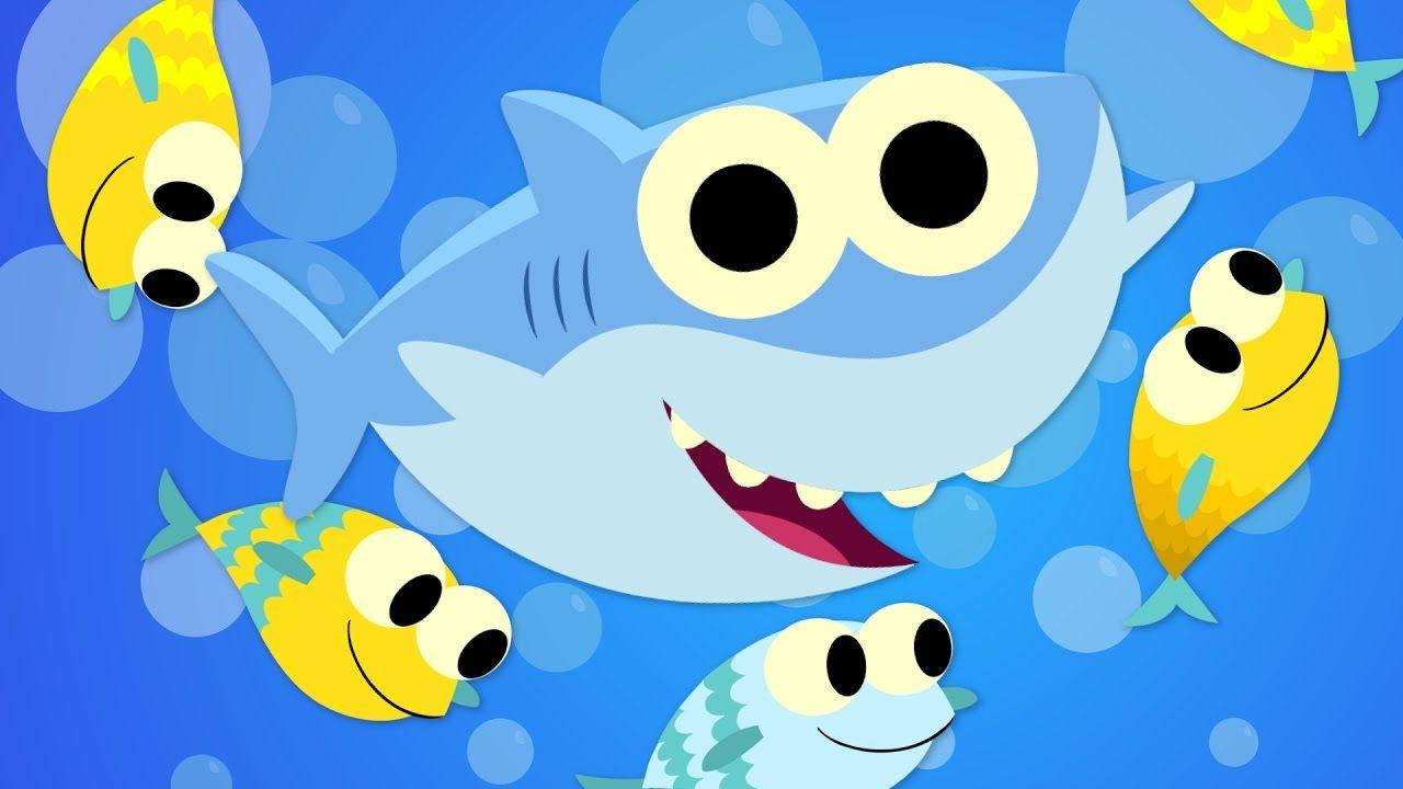 一隻微笑的卡通鯊魚在水下被黃色魚和氣泡包圍。 — 魚 GIF 壁紙
