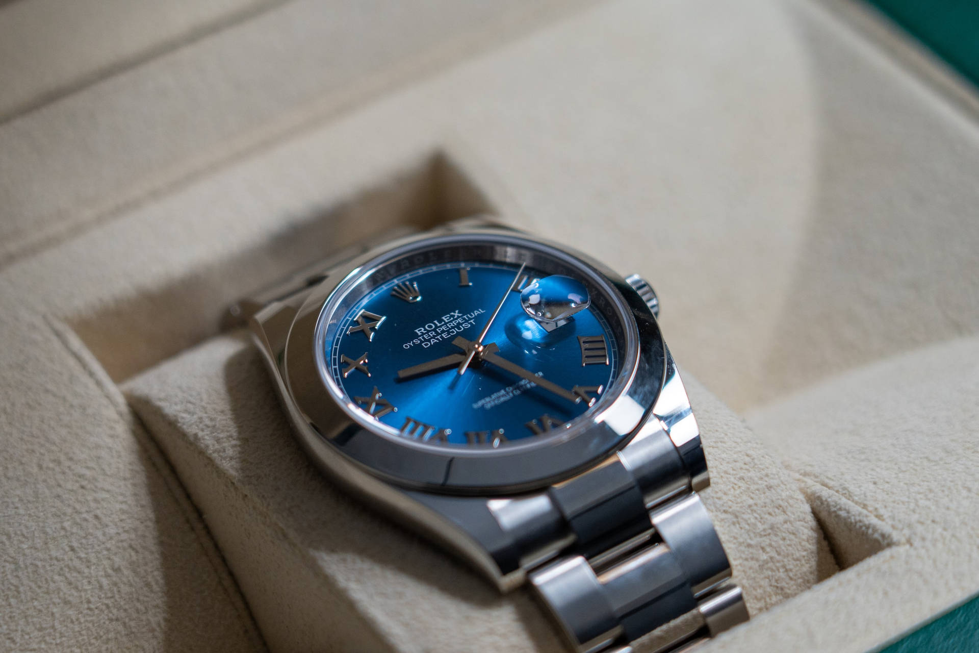 藍色 桌布 壁紙 — 一隻奢華的勞力士Oyster Perpetual，配以充滿活力的藍色錶盤，優雅地安放在其奶油色的展示盒中。