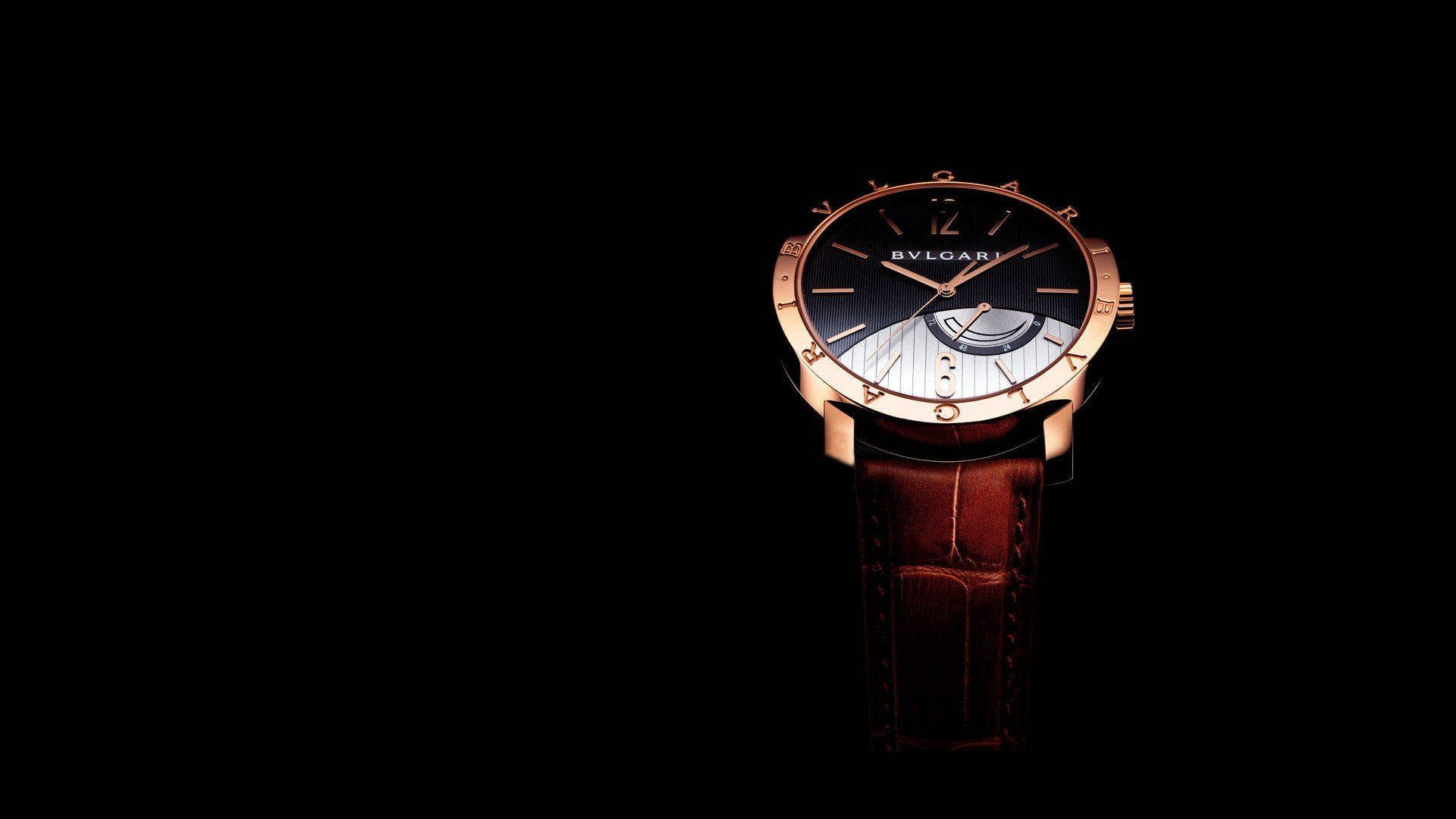 Bvlgari 桌布 壁紙 — 一隻奢華的玫瑰金寶格麗手錶，配備黑色錶盤和棕色皮革錶帶，在純黑背景下脫穎而出。