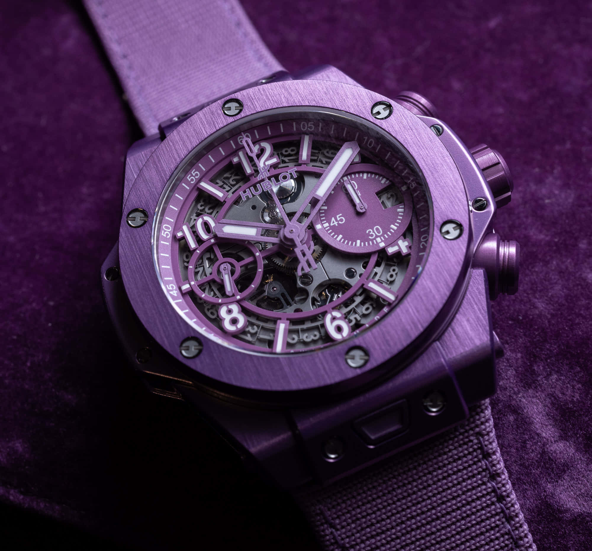 Purple Watch 桌布 壁紙 — 一隻奢華的紫色Hublot手錶，鏤空錶盤，放在相配的天鵝絨表面上。