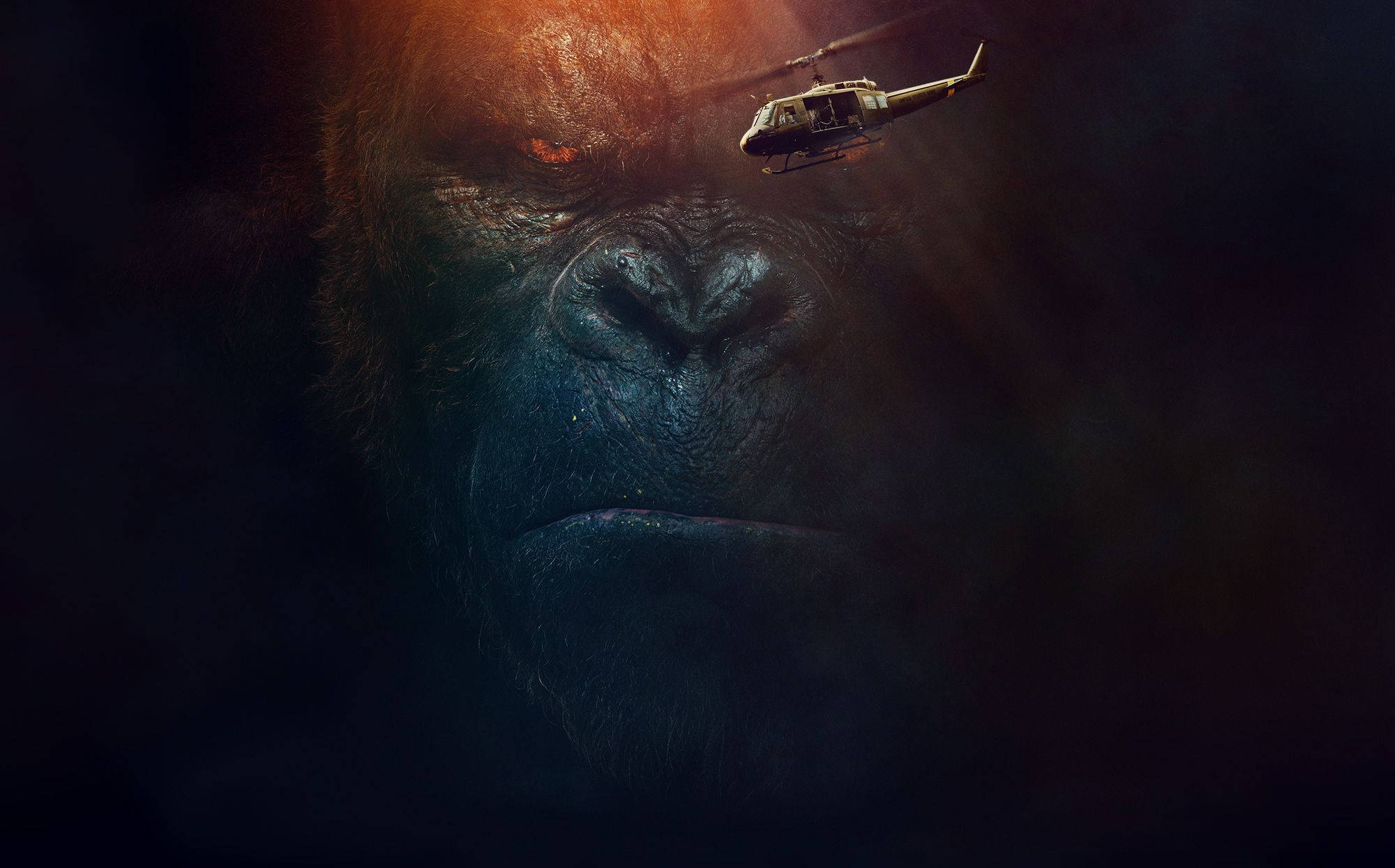 Gorilla 桌布 壁紙 — 一隻巨型大猩猩的強烈面孔在黑暗中隱現，一架直升機在戲劇性燈光下飛過它的眉頭。