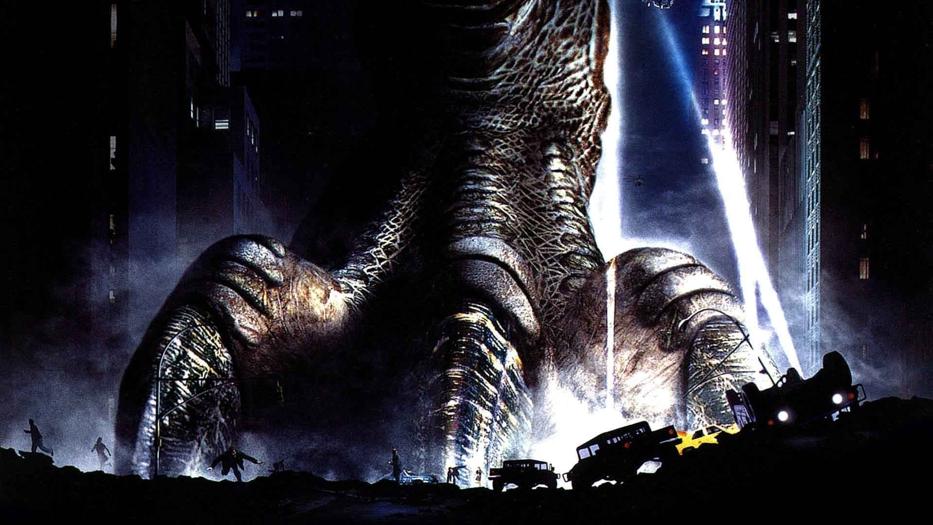 godzilla 1998 桌布 壁紙 — 一隻巨大怪獸的巨腳在夜間壓碎城市街道，探照燈刺穿黑暗。