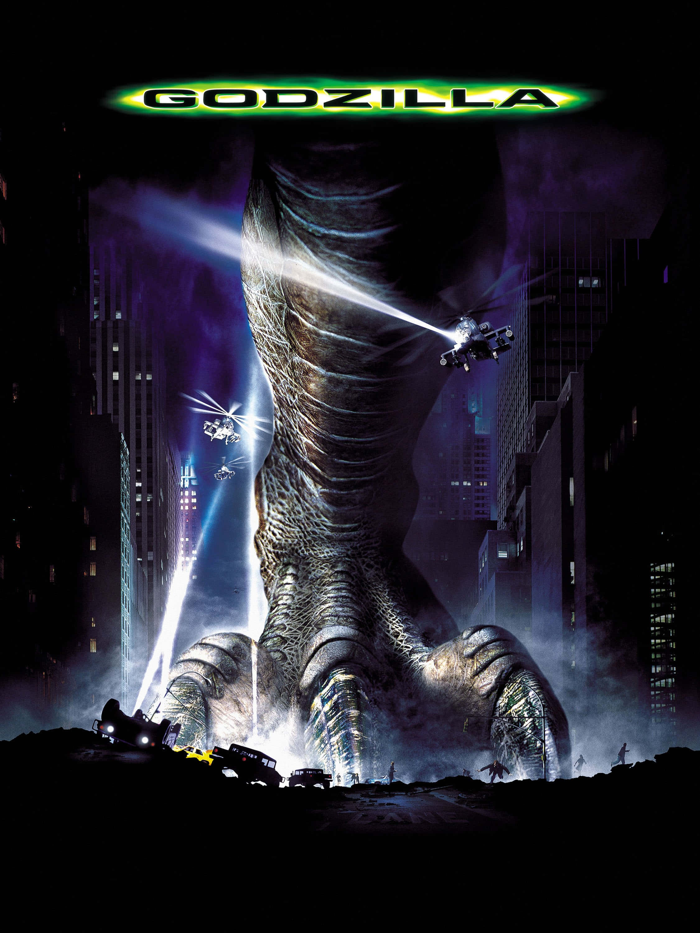 godzilla 1998 桌布 壁紙 — 一隻巨大的哥吉拉在夜晚籠罩著城市，直升機向其巨大的腳發射光束。
