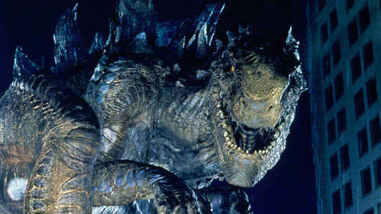 godzilla 1998 桌布 壁紙 — 一隻巨大的哥吉拉在夜間籠罩著城市，眼睛發光，背鰭呈鋸齒狀。