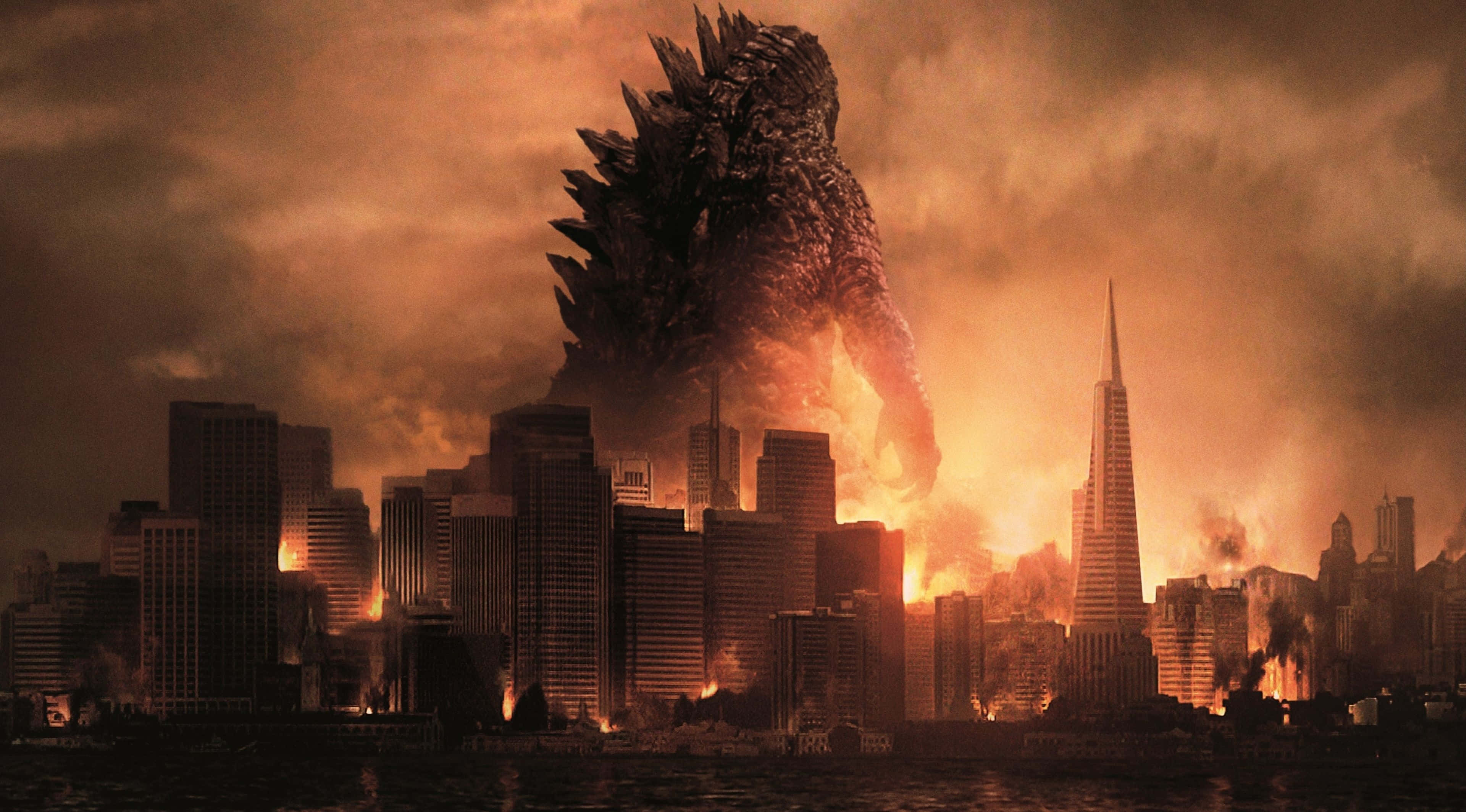 Godzilla 2014 桌布 壁紙 — 一隻巨大的哥吉拉聳立在燃燒的城市景觀之上，摩天大樓在烈火和濃煙中倒塌。